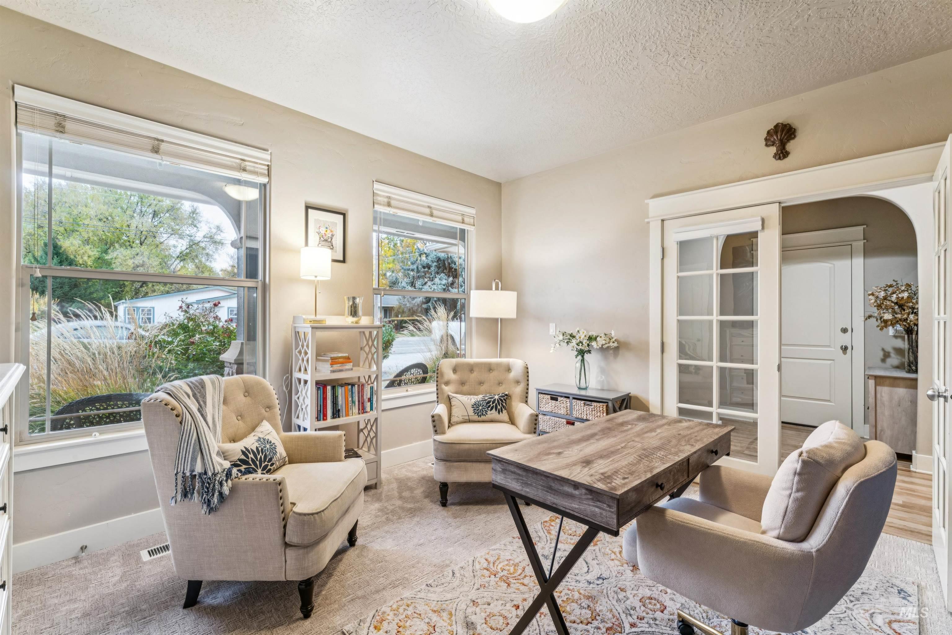 Carpeted office space featuring a textured ceiling and arched walkways