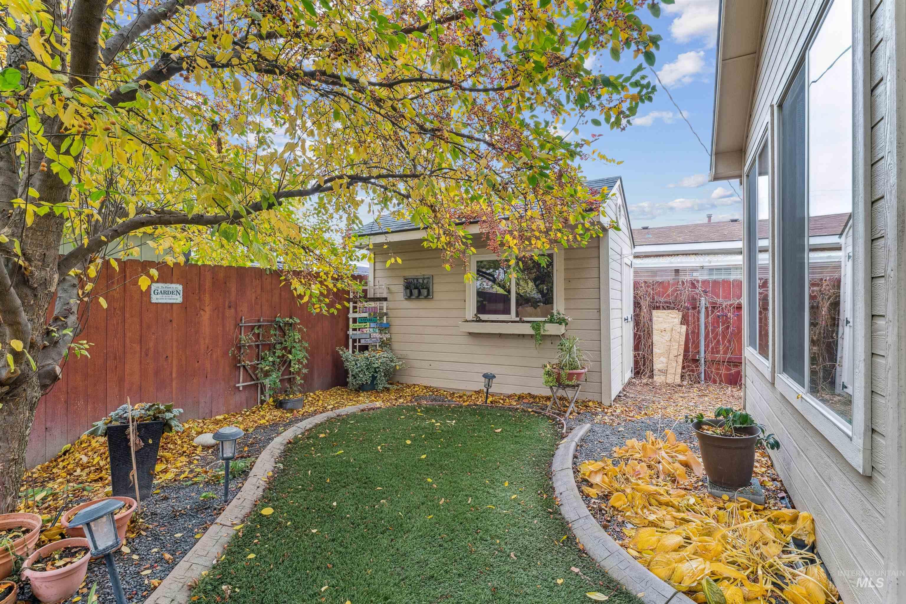 Fenced backyard featuring an outdoor structure