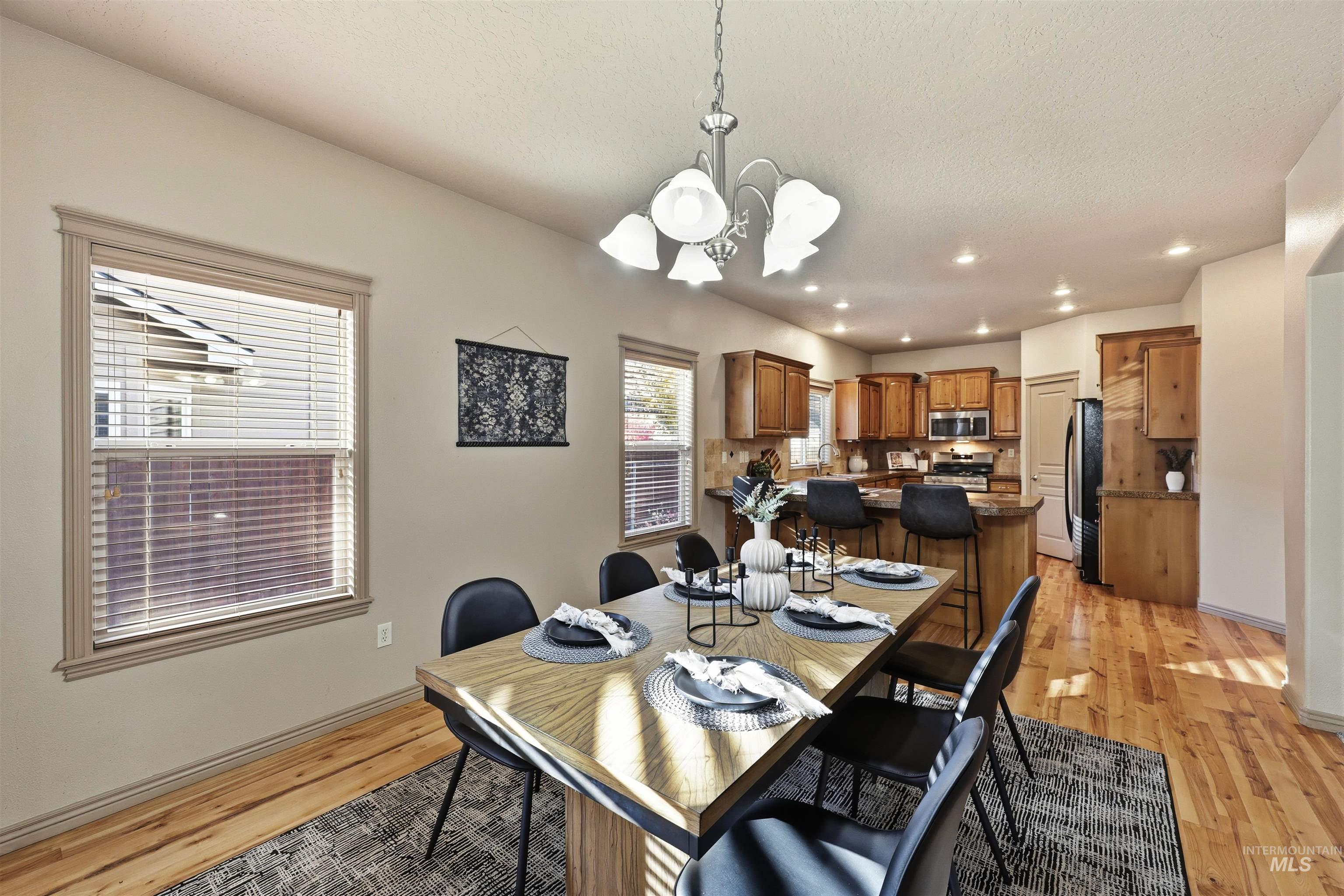 Dining room featuring light wood finished floors, recessed lighting, and a chandelier