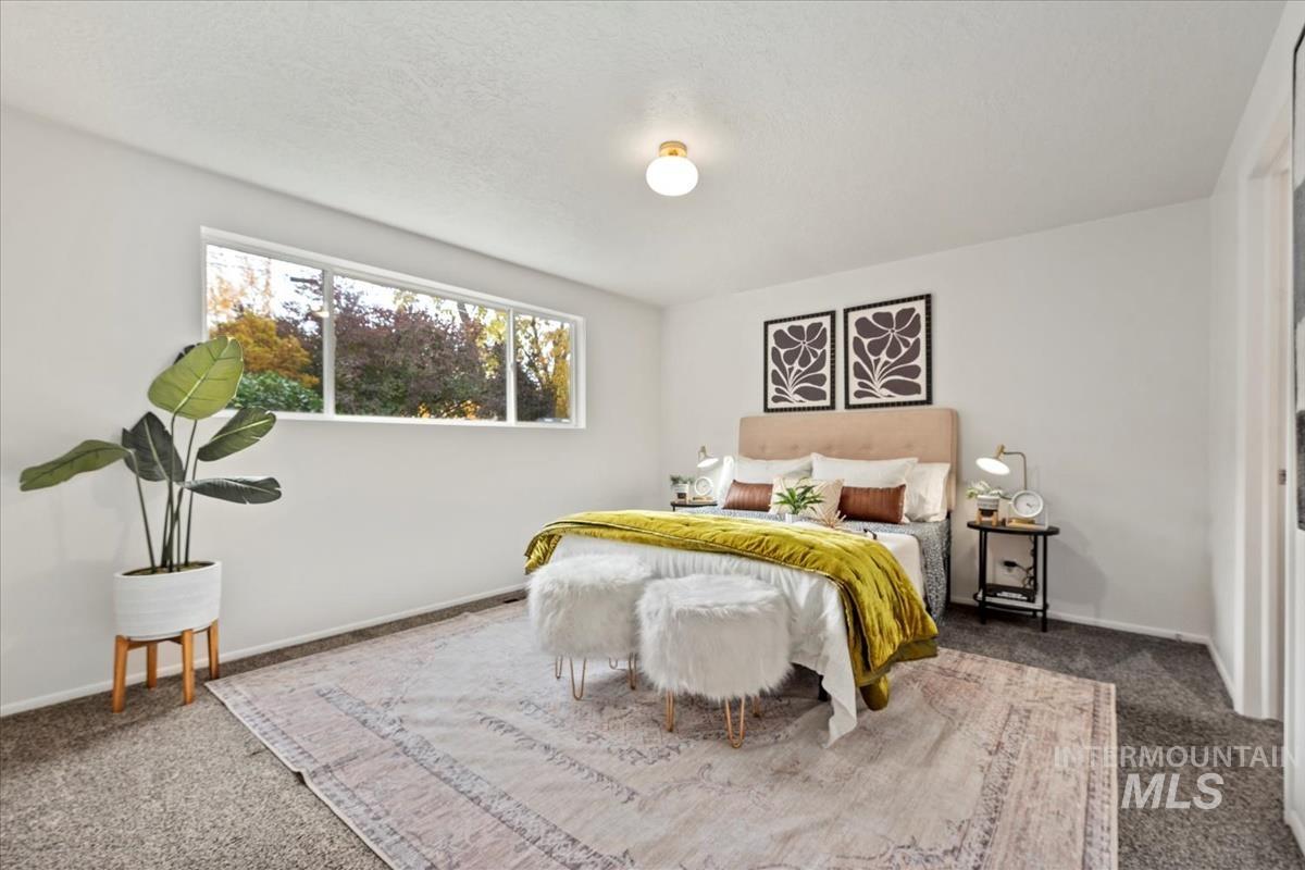 Bedroom featuring carpet and a textured ceiling