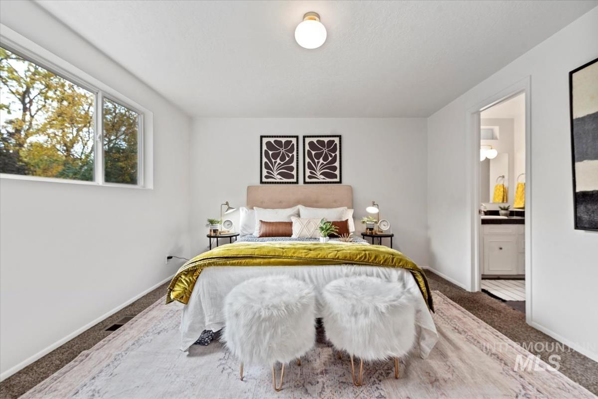 Carpeted bedroom featuring baseboards and ensuite bath