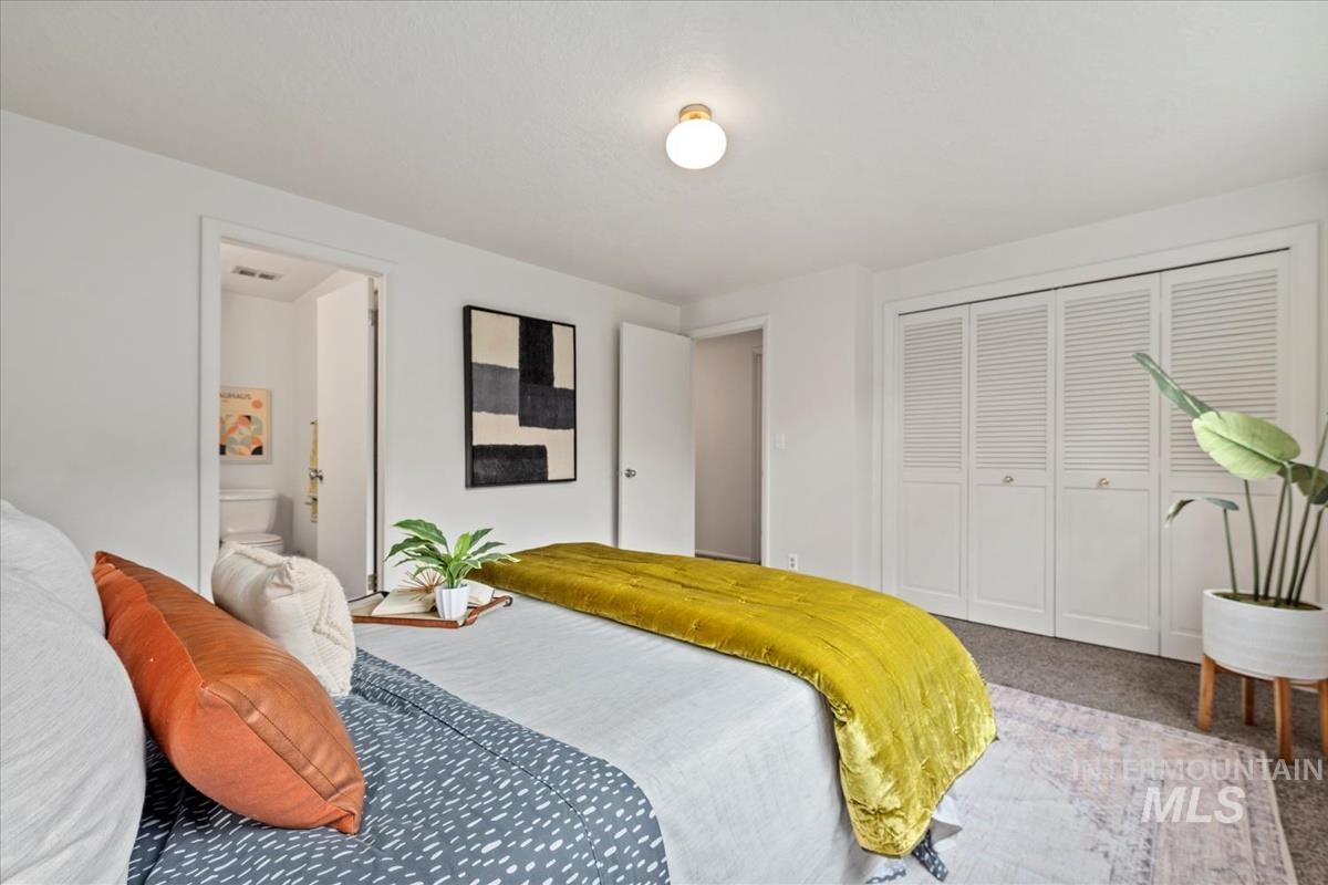 Bedroom with carpet floors, a closet, and ensuite bath
