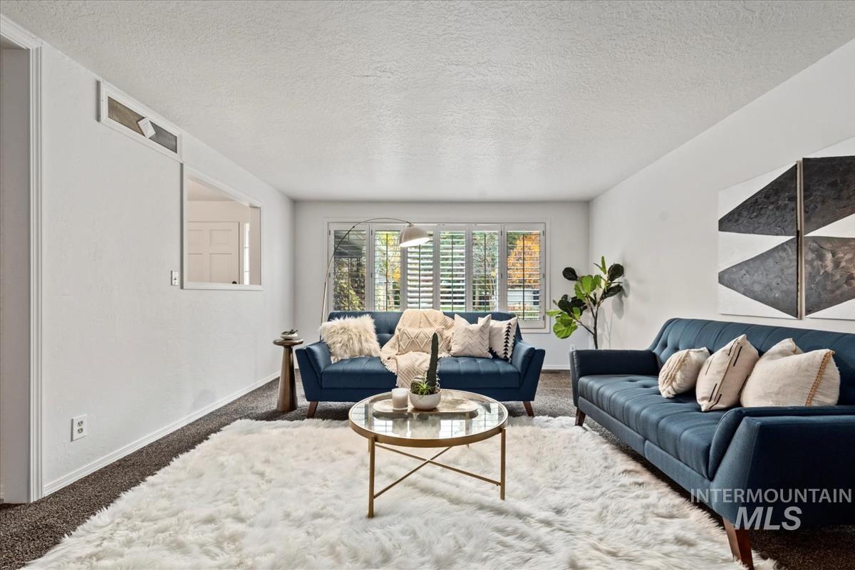 Living area with carpet flooring and a textured ceiling