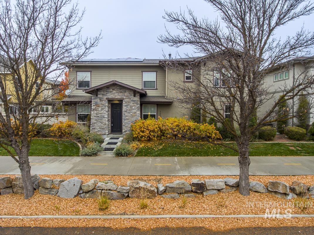 View of front of home featuring solar panels and stone siding
