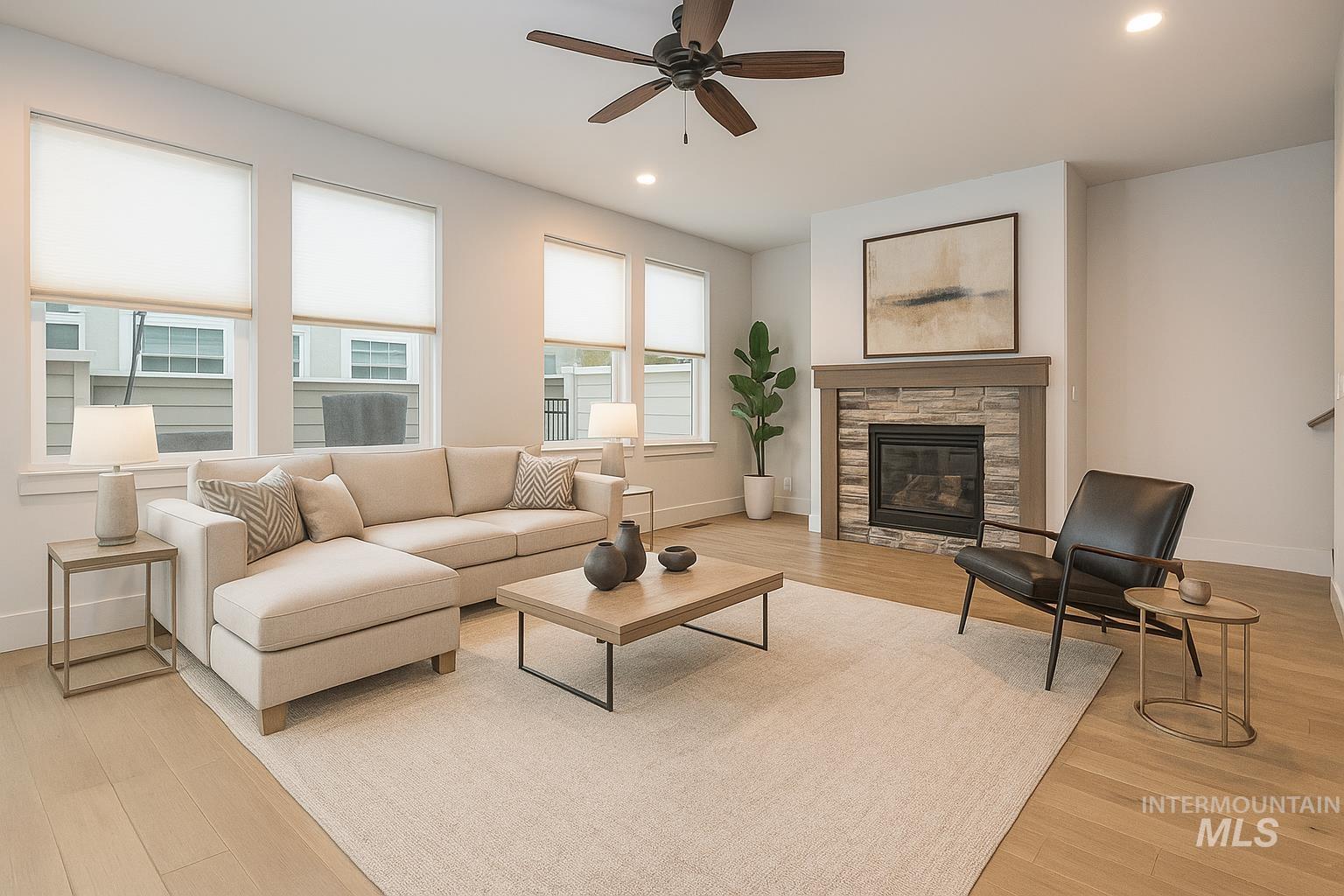 Living room featuring light wood-style flooring, recessed lighting, ceiling fan, and a fireplace