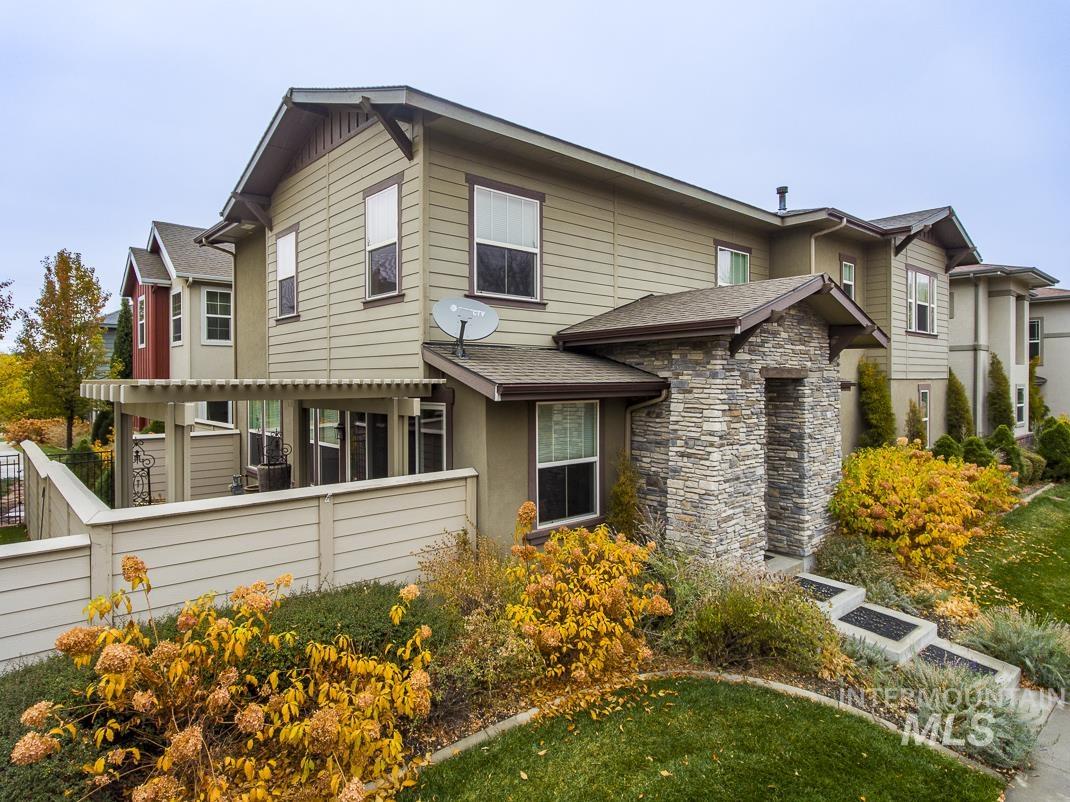 View of front facade featuring stone siding and a shingled roof