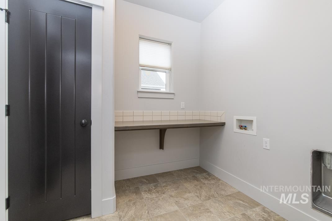 Washroom with baseboards and hookup for a washing machine