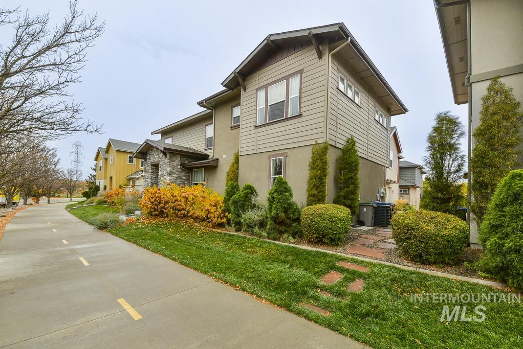 View of side of property featuring a lawn and stone siding