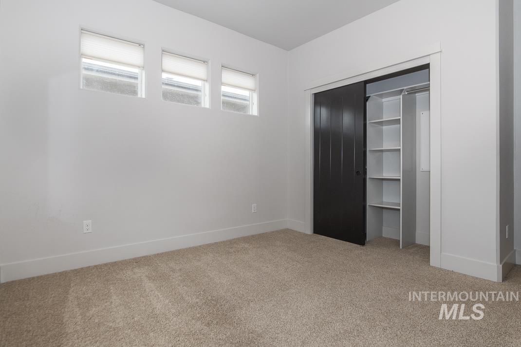 Unfurnished bedroom with light carpet and a closet