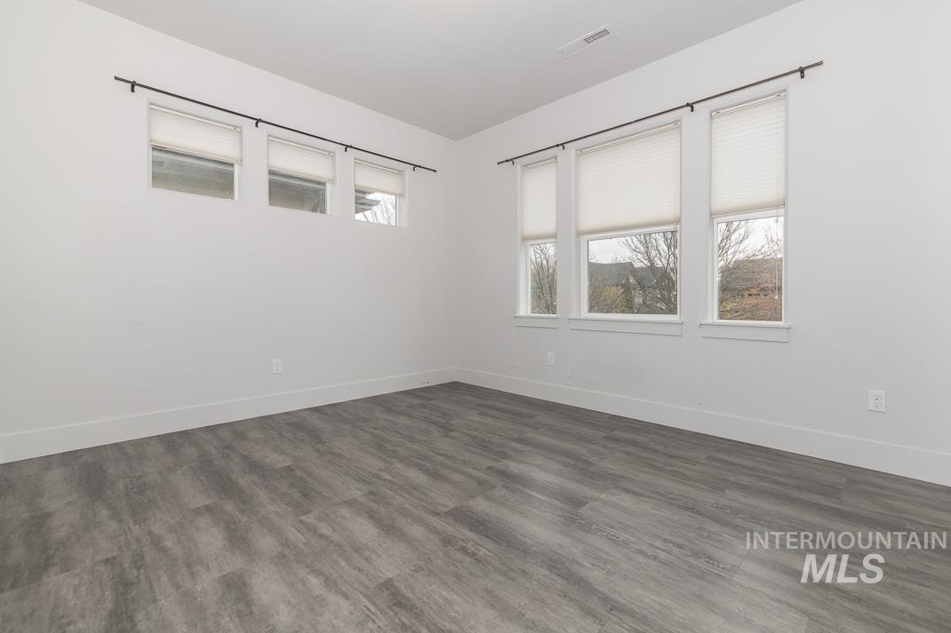 Empty room with dark wood-style floors and baseboards