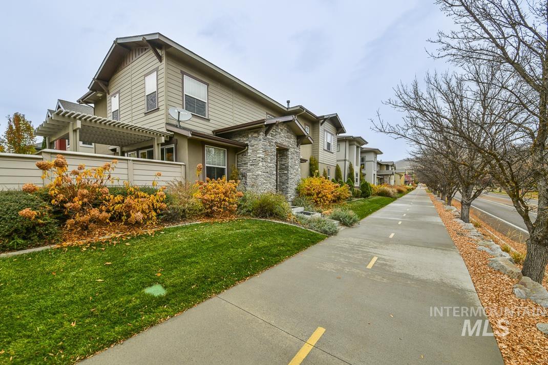 View of side of home with stone siding, a lawn, and a residential view