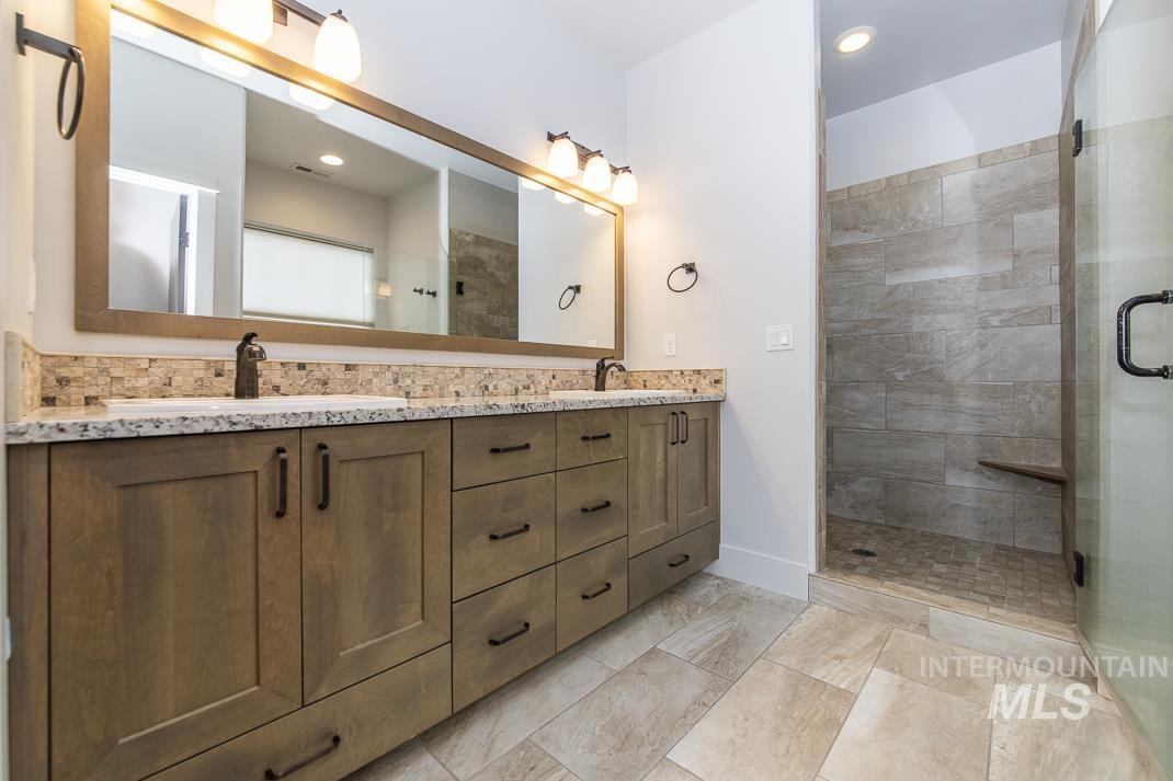 Bathroom with double vanity, a stall shower, and recessed lighting