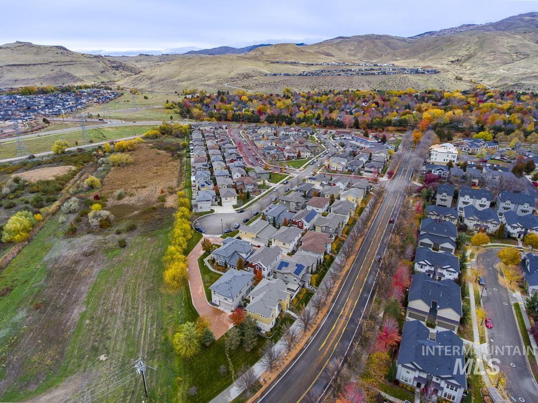 Aerial view of property and surrounding area featuring nearby suburban area and mountains