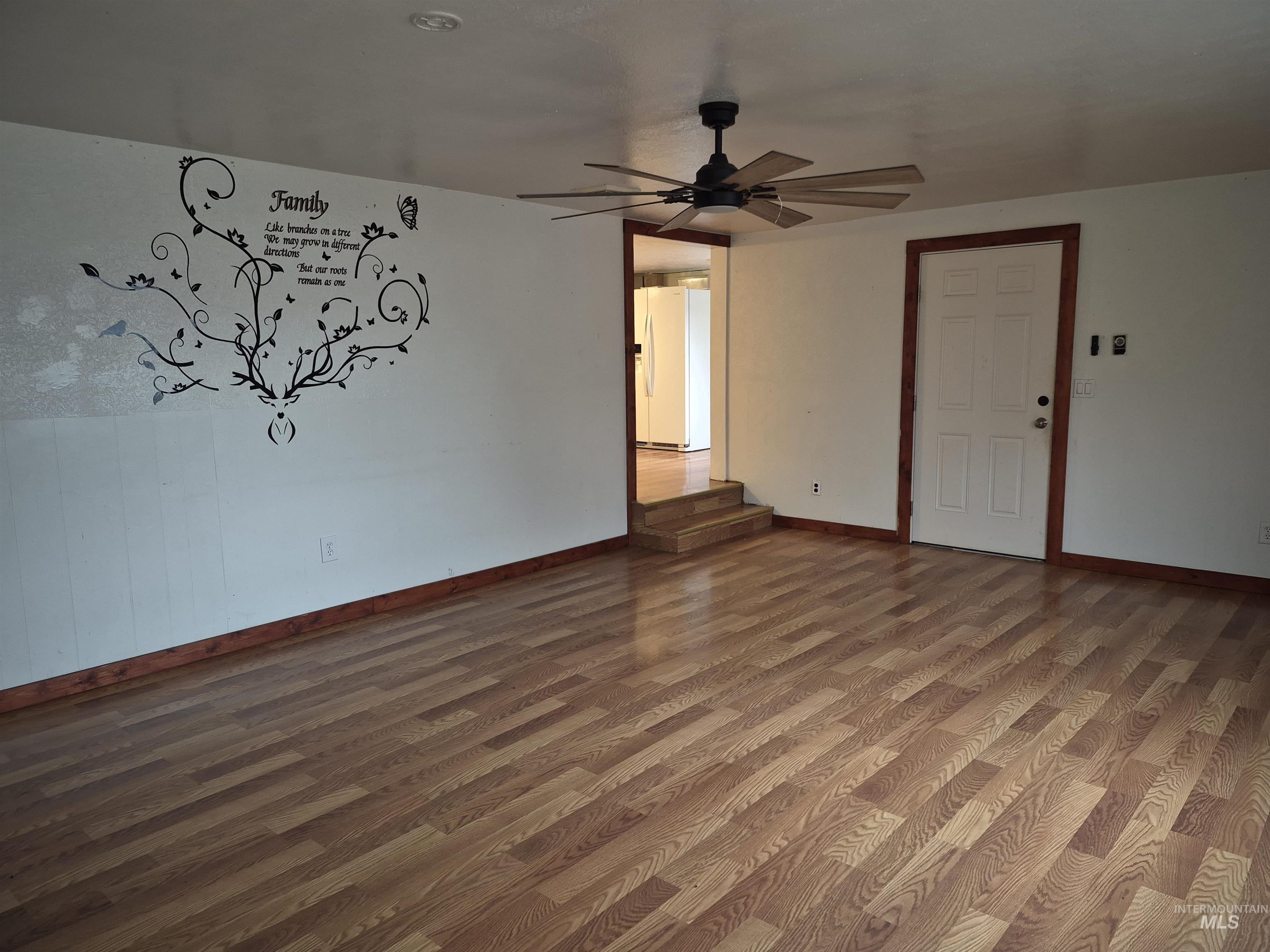 Spare room with wood finished floors and a ceiling fan