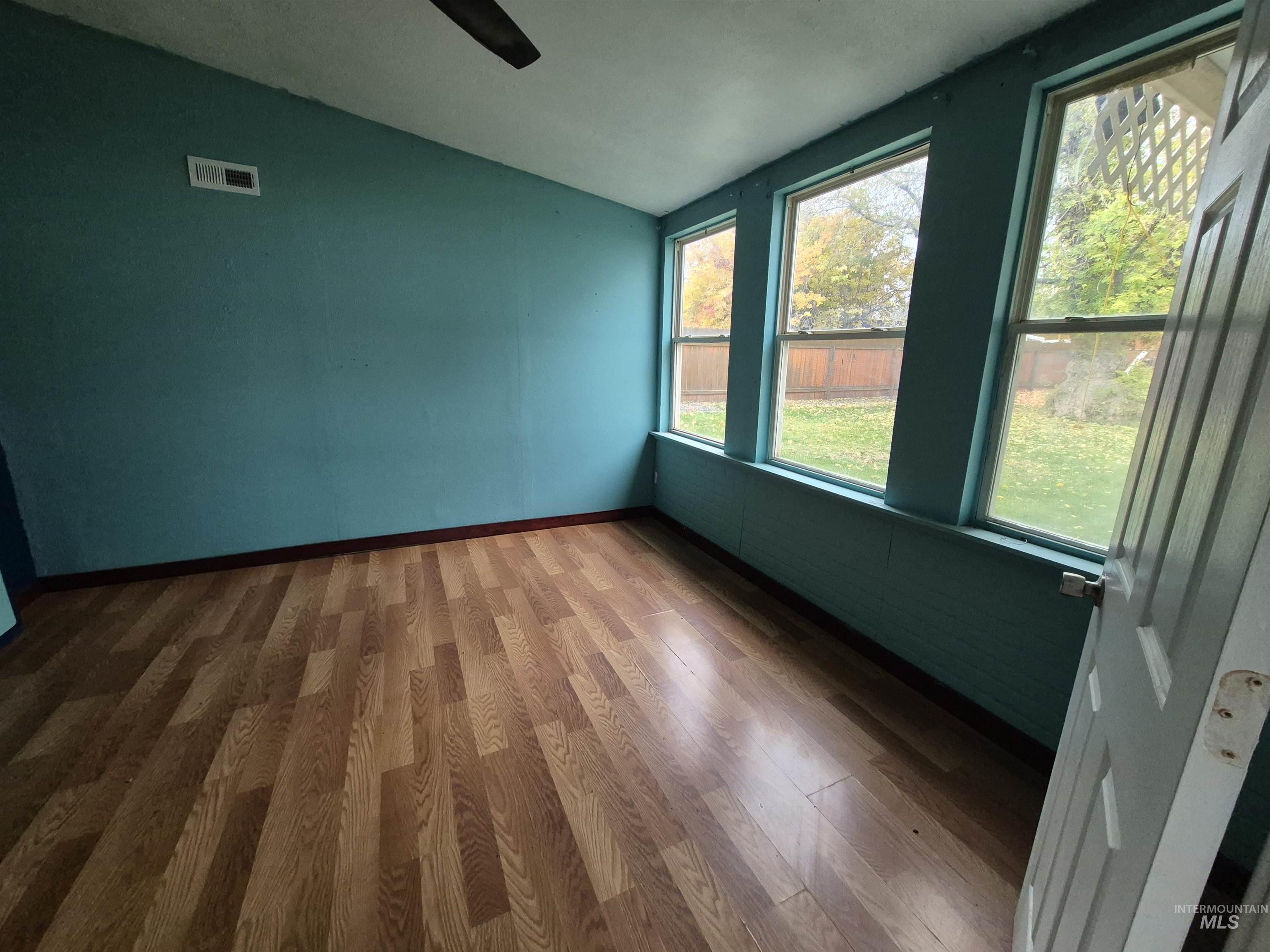 Empty room with wood finished floors and lofted ceiling