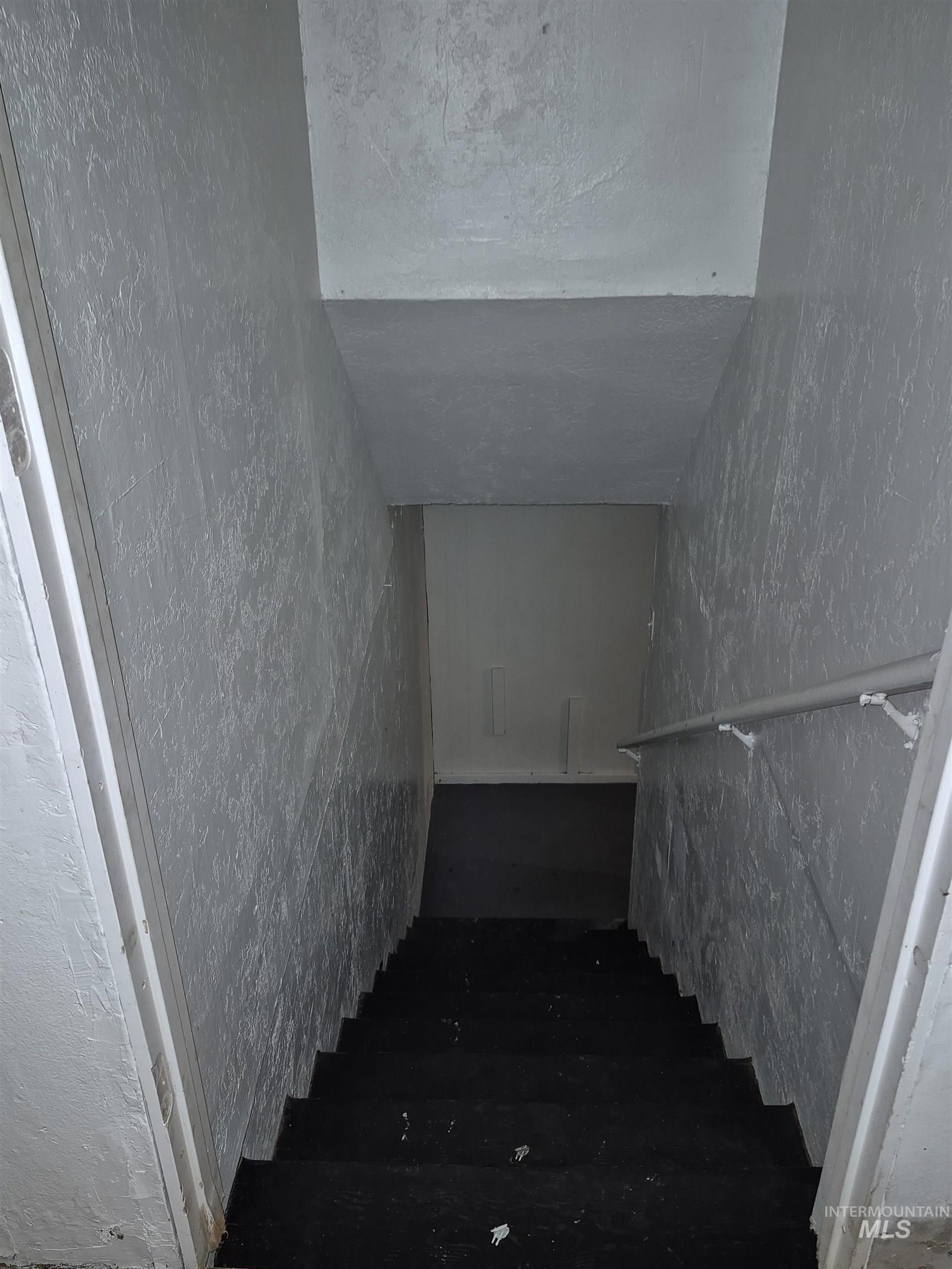 Staircase featuring a textured ceiling