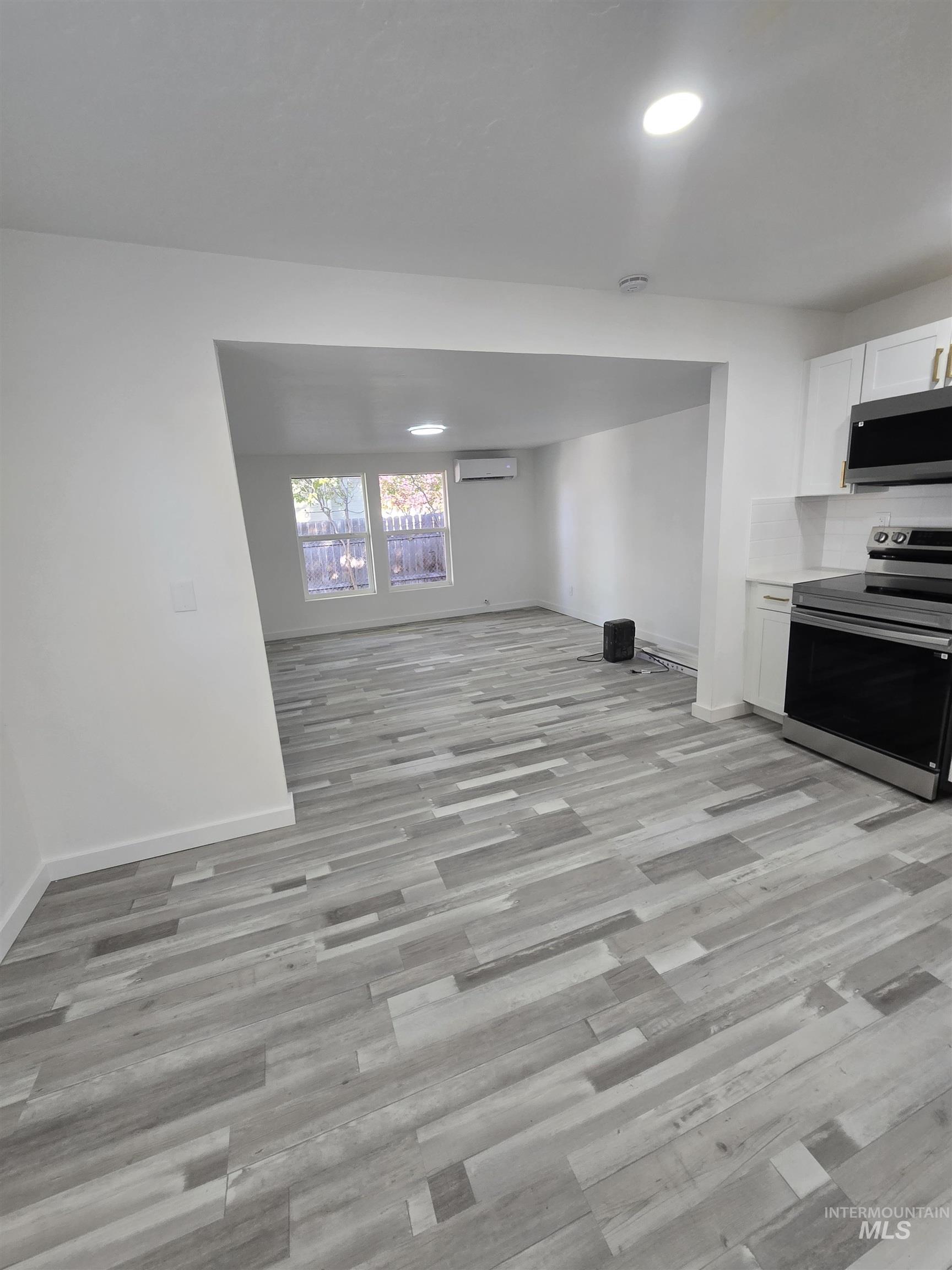 Unfurnished living room featuring light wood-style flooring and recessed lighting