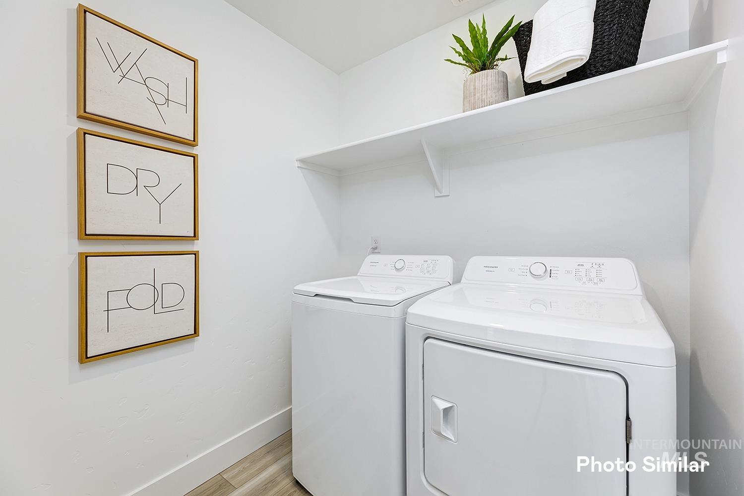 Washroom with separate washer and dryer and light wood finished floors