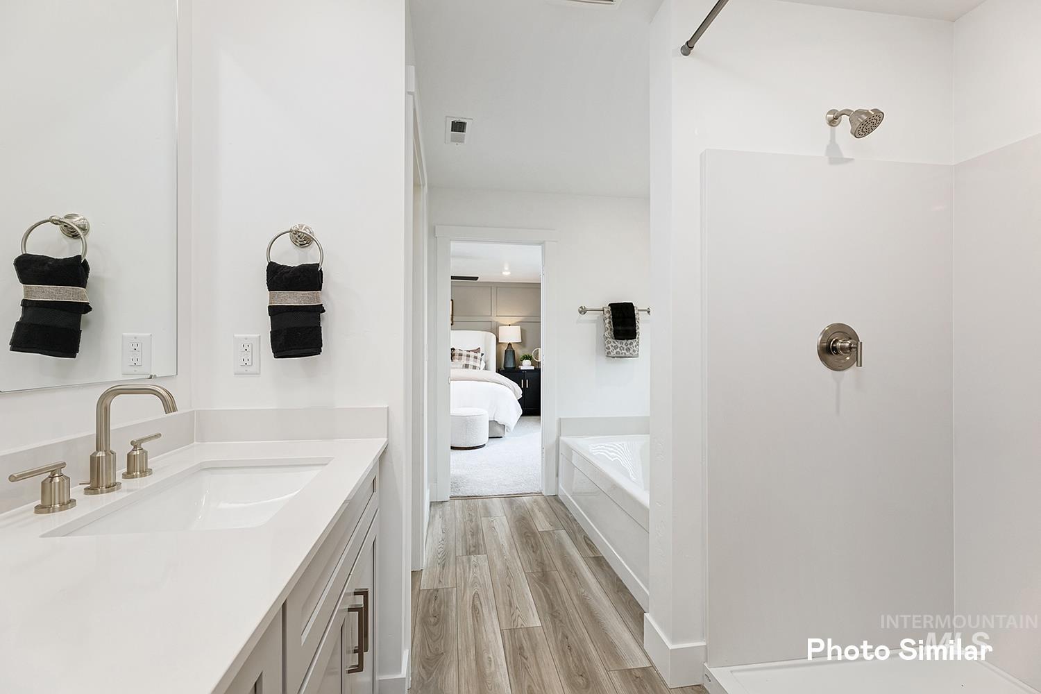 Ensuite bathroom with a shower, vanity, a garden tub, and light wood finished floors
