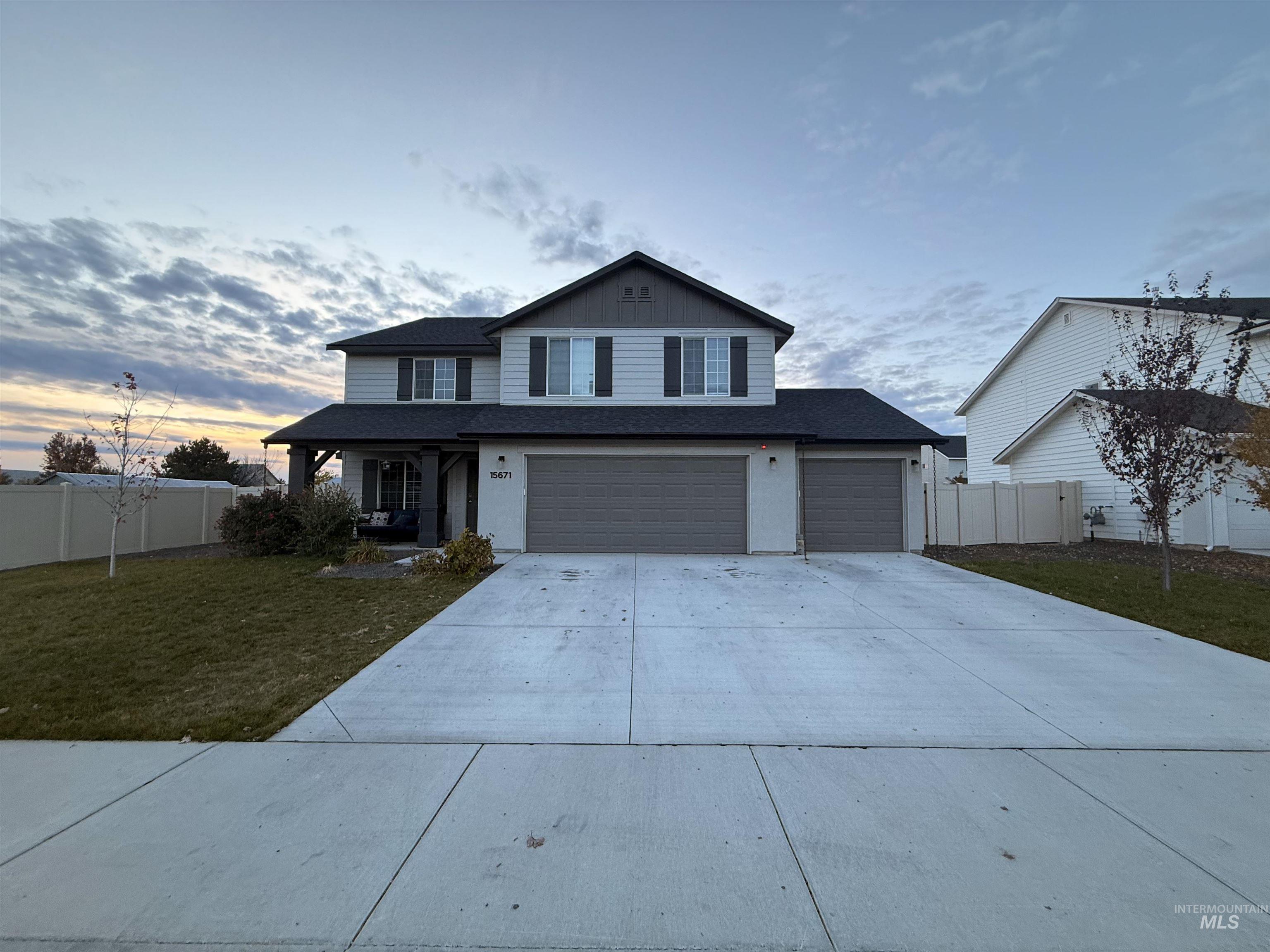 Traditional-style house with concrete driveway, a porch, an attached garage, and a shingled roof