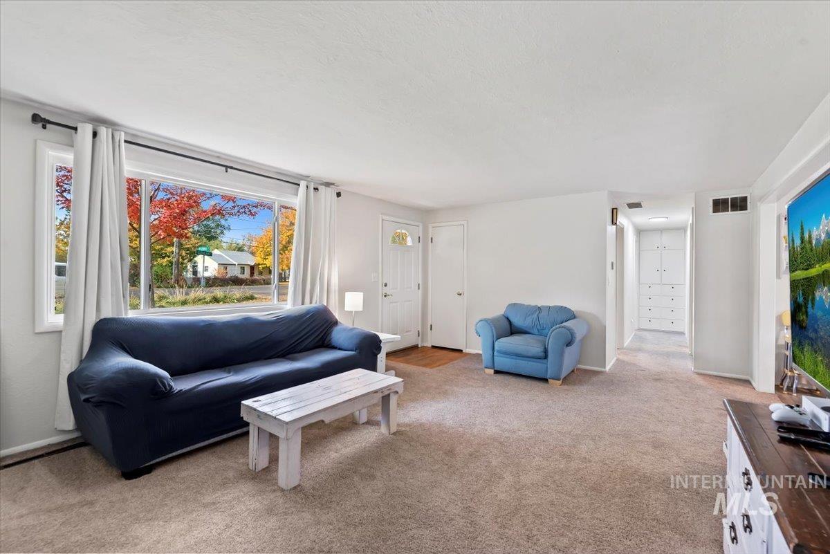 Living area with light colored carpet and baseboards