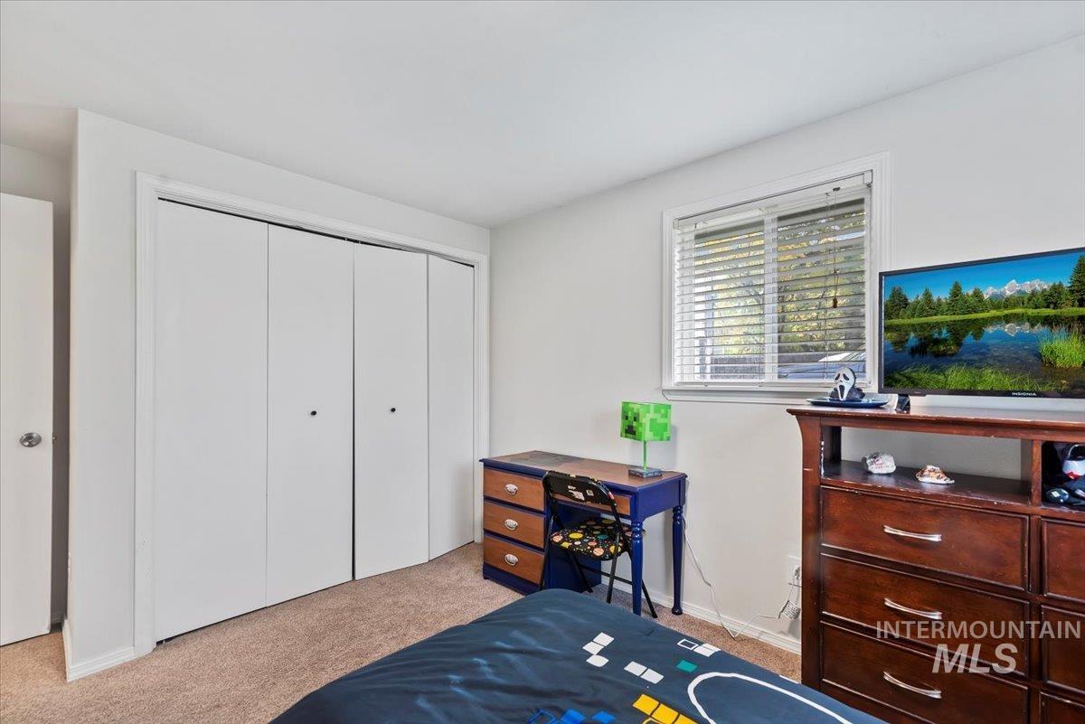 Bedroom with light carpet and a closet