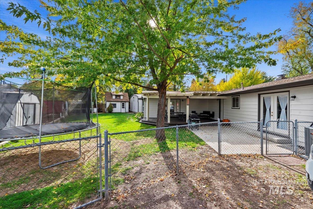 Rear view of property with a storage unit, a gate, and french doors