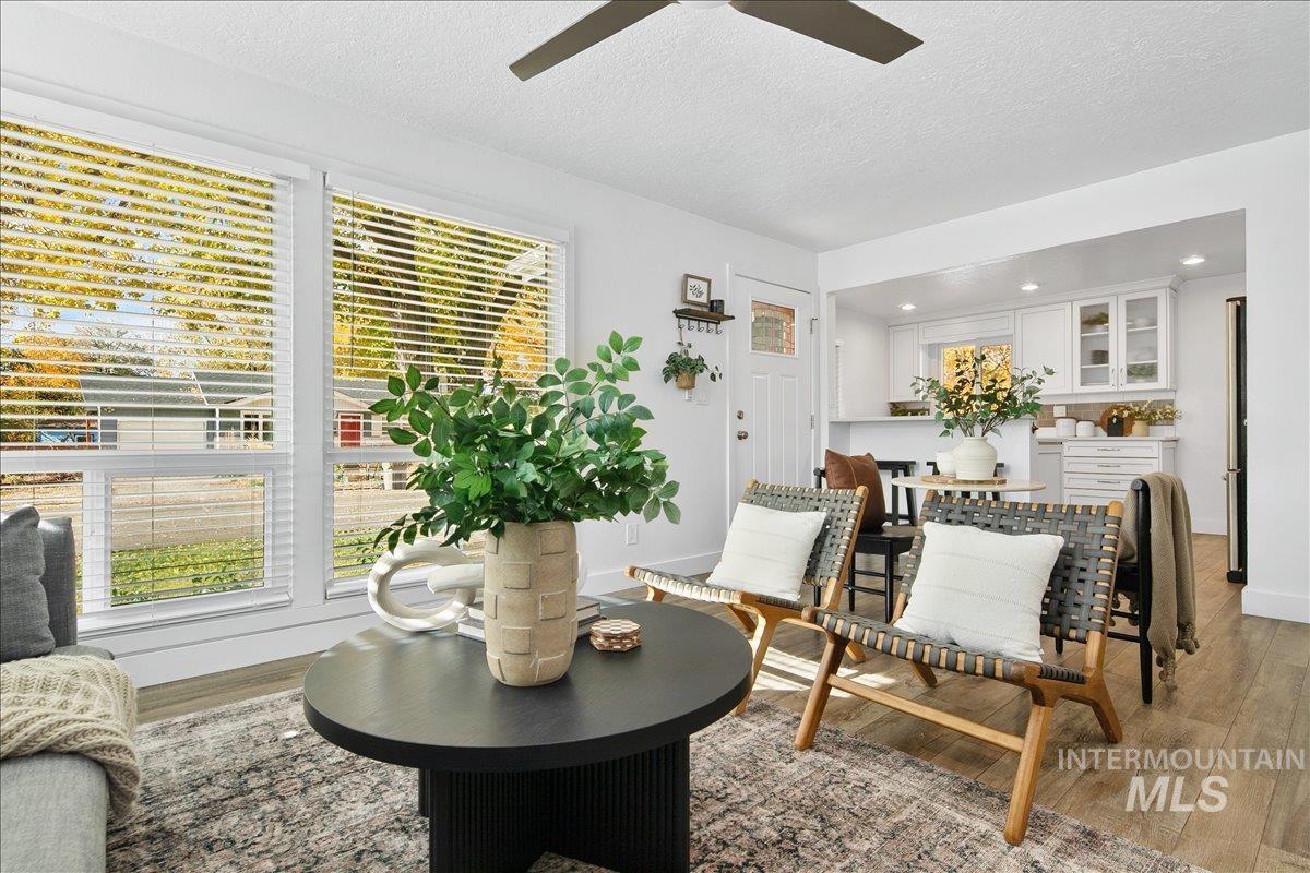 Living area featuring wood finished floors, a textured ceiling, a ceiling fan, and recessed lighting