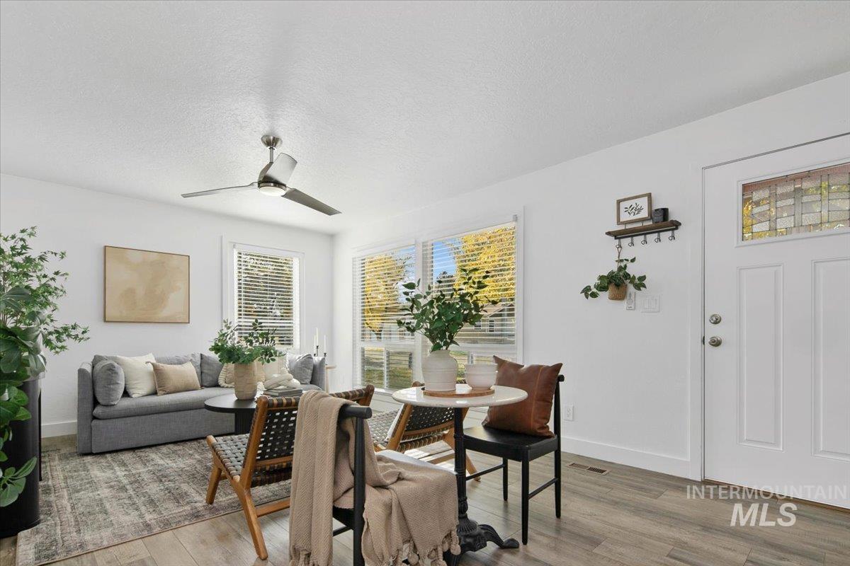 Dining room featuring a textured ceiling, light wood-style floors, and a ceiling fan