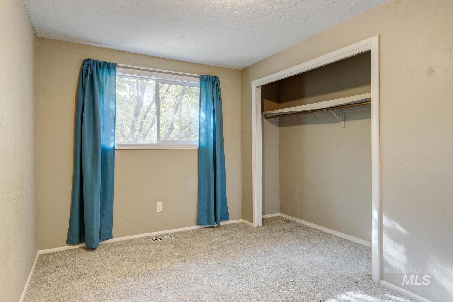 Unfurnished bedroom with carpet, a closet, and a textured ceiling