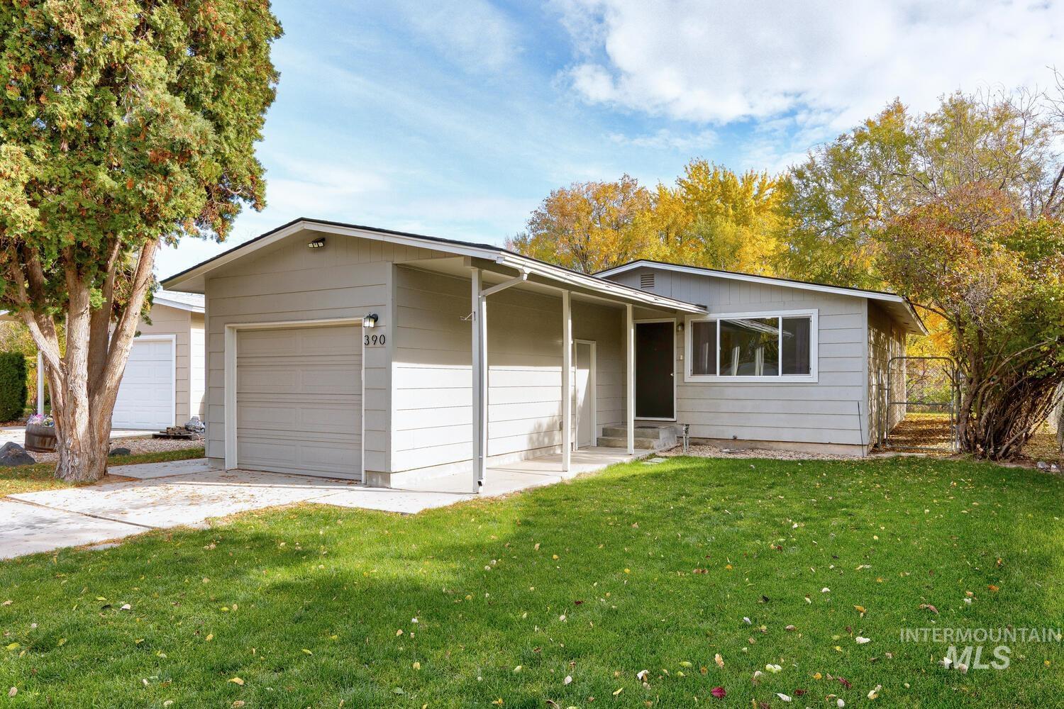 Ranch-style home with a front lawn, driveway, and a garage