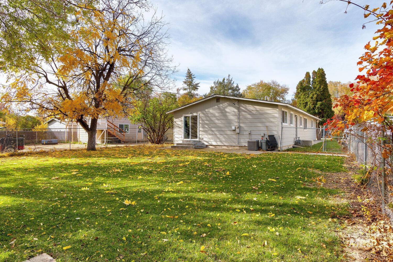 Back of house featuring a fenced backyard, entry steps, and a gate