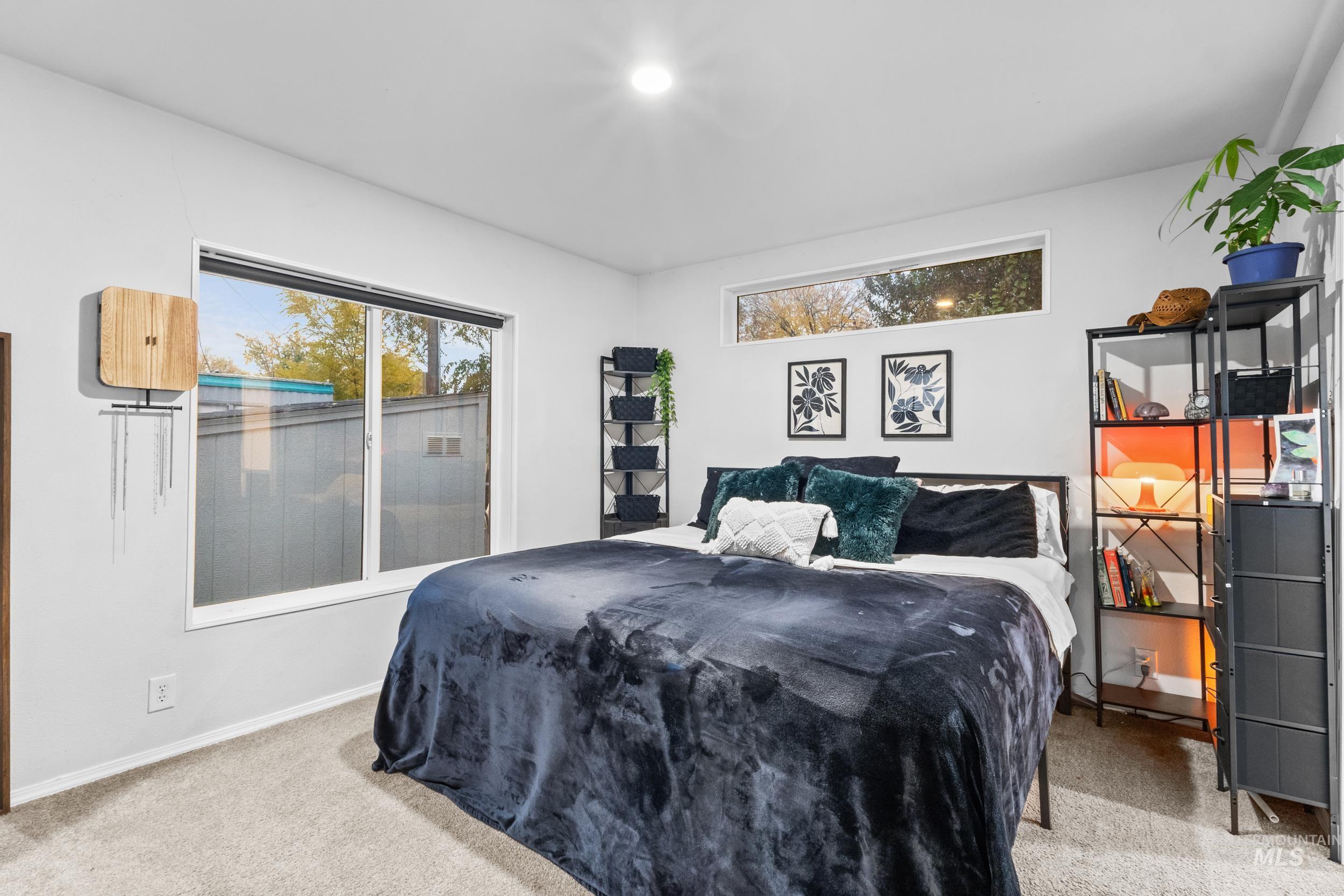 Bedroom with light colored carpet and baseboards
