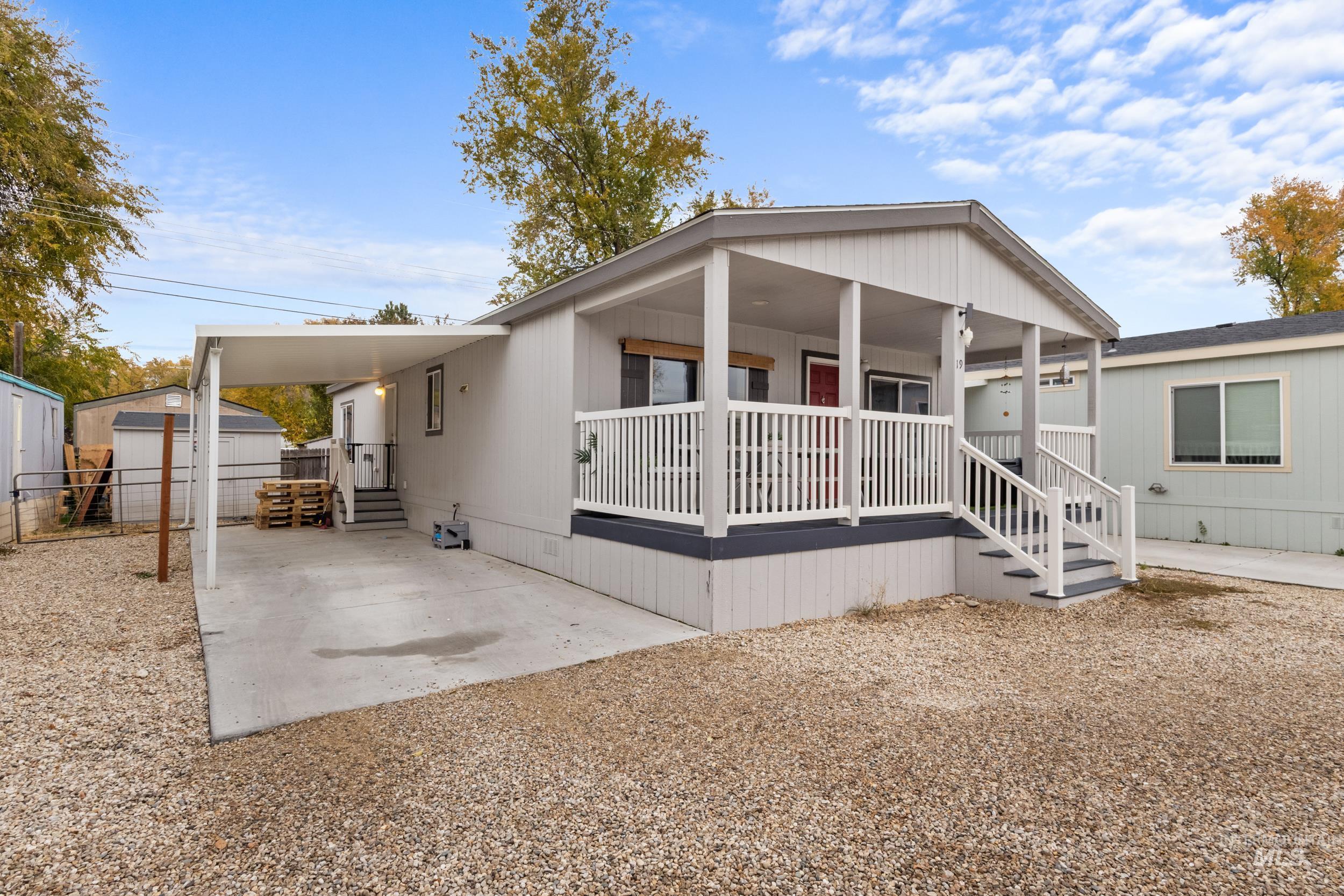Manufactured / mobile home featuring covered porch, a storage shed, and a carport