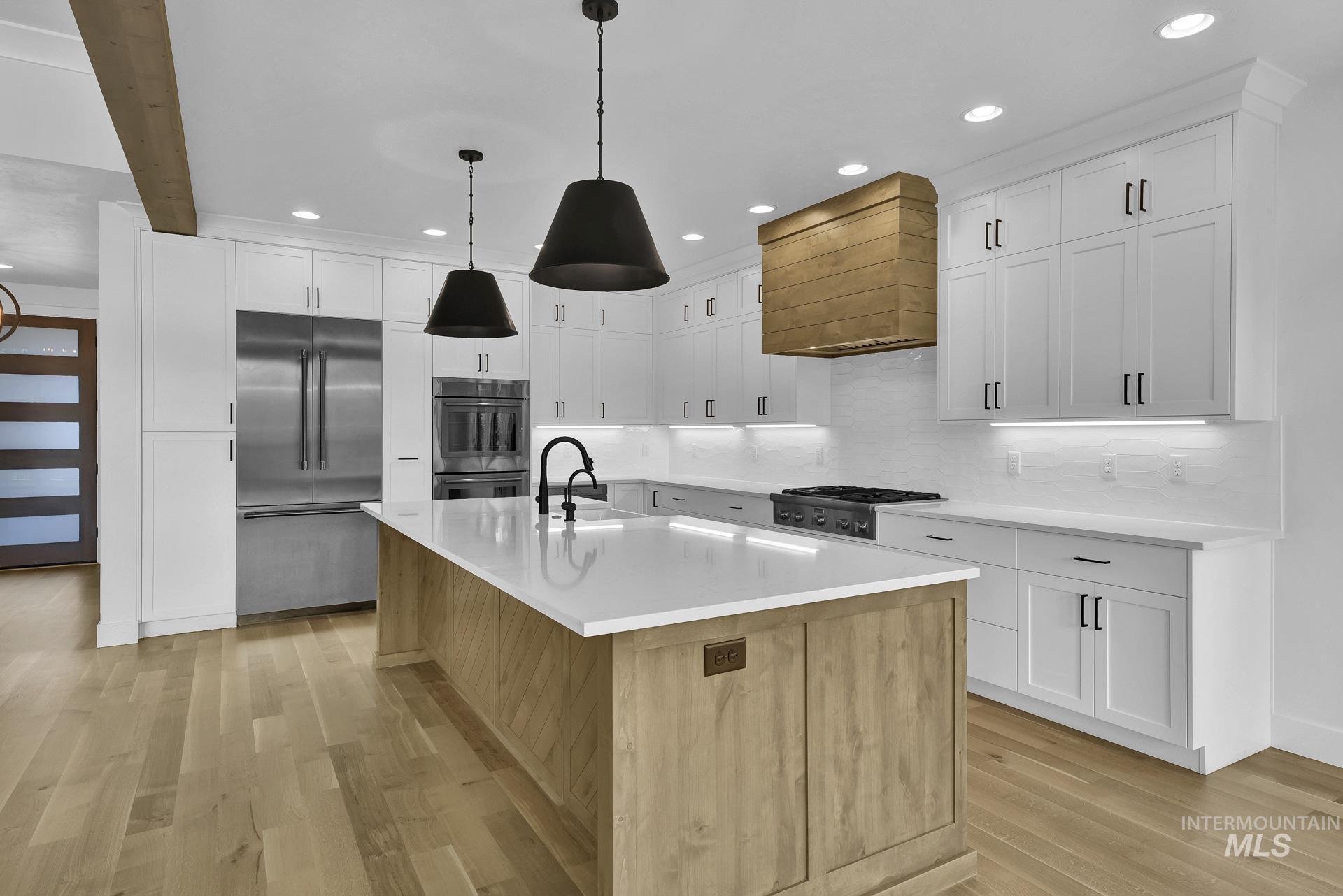 Kitchen featuring light wood-style floors, stainless steel appliances, recessed lighting, decorative backsplash, and premium range hood