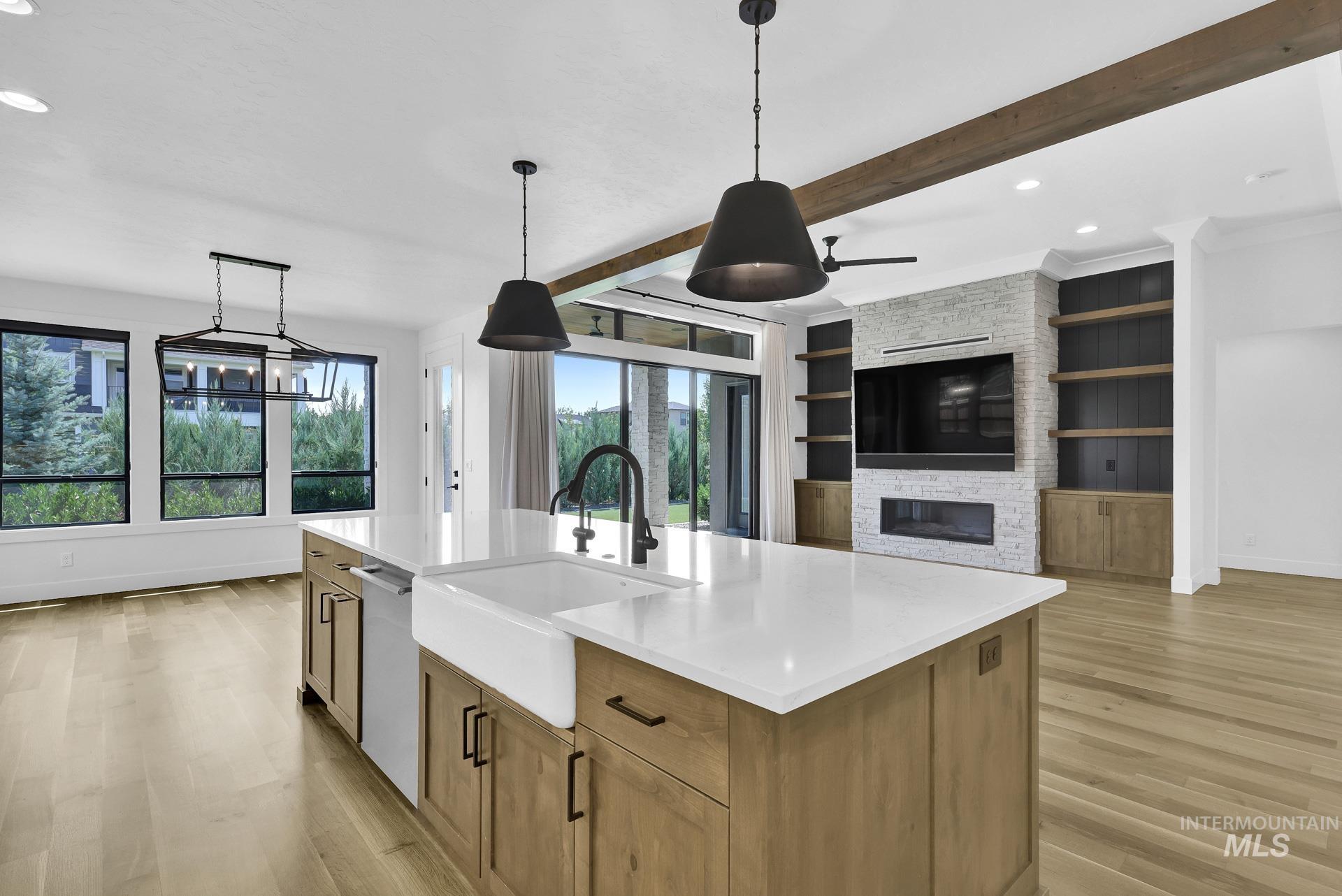 Kitchen featuring light wood-style flooring, recessed lighting, light countertops, decorative light fixtures, and beamed ceiling