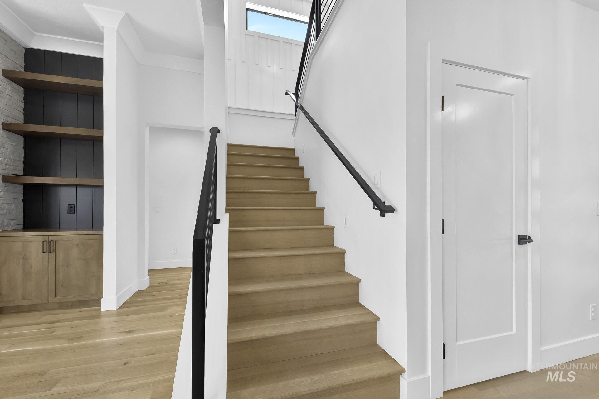Stairs with wood finished floors and baseboards