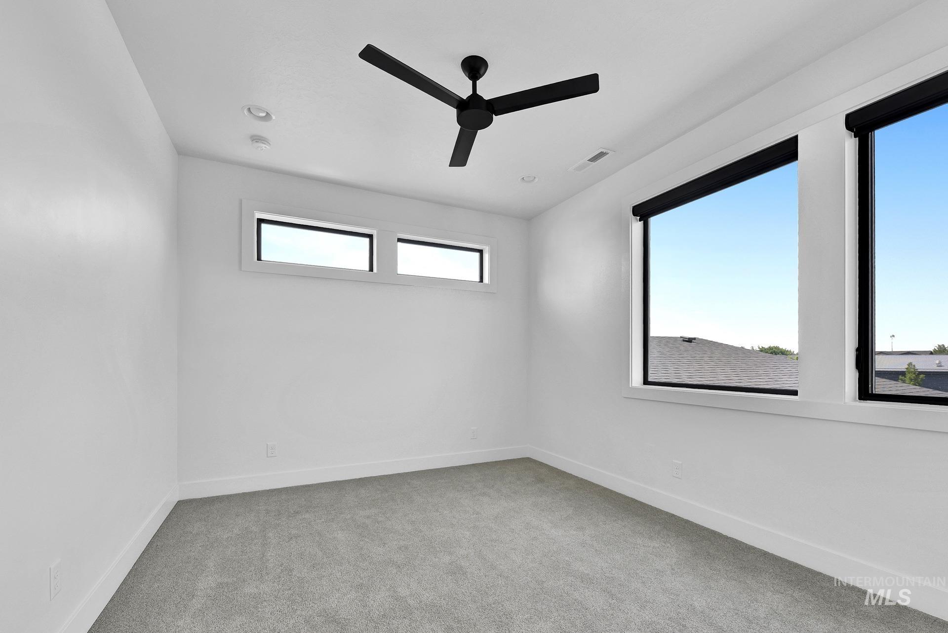 Unfurnished room featuring ceiling fan and carpet flooring