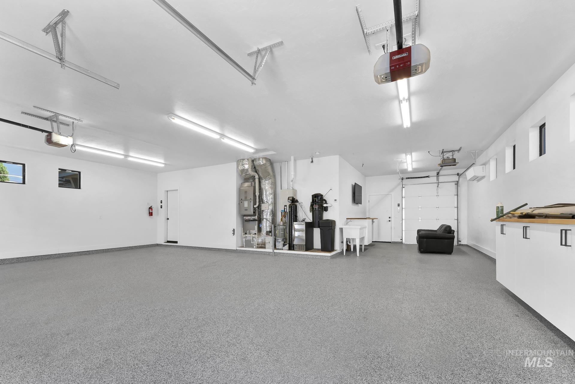 Garage featuring a garage door opener and heating unit