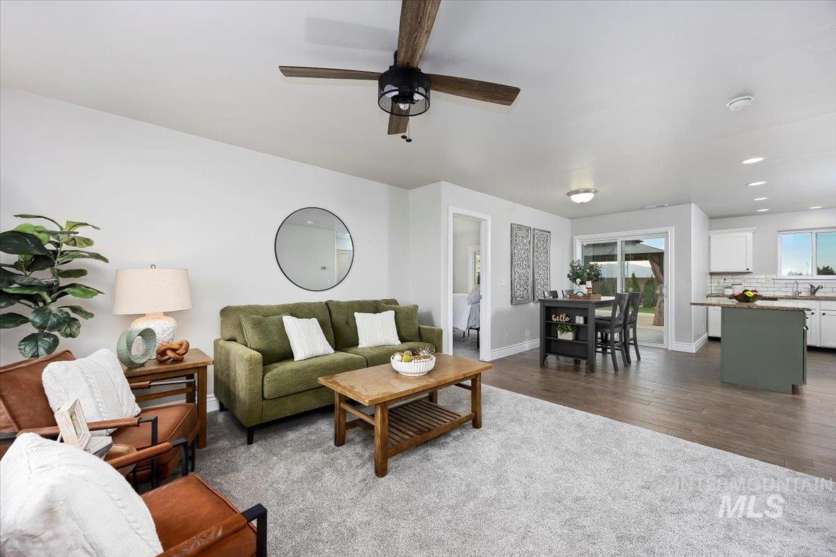 Living area with recessed lighting, dark wood-style flooring, and ceiling fan