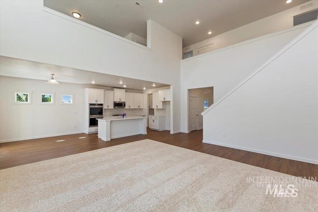 Unfurnished living room featuring dark wood finished floors and recessed lighting