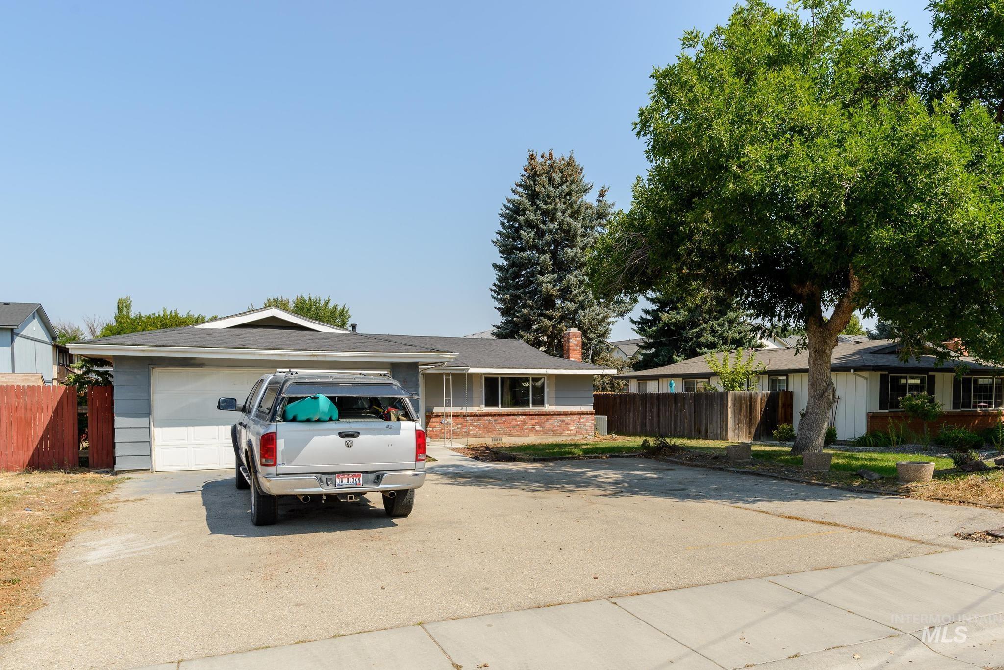 Ranch-style house with concrete driveway, a chimney, and a garage
