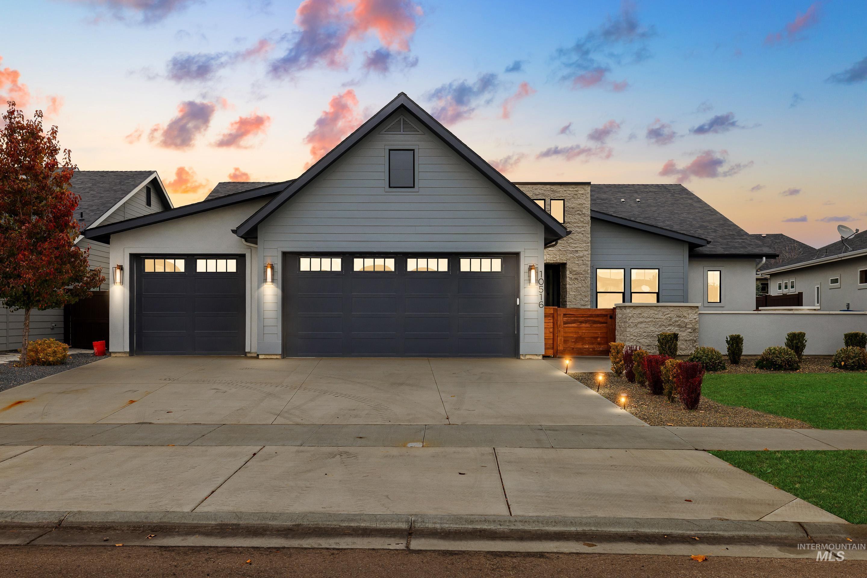 Modern inspired farmhouse with concrete driveway, an attached garage, and stucco siding