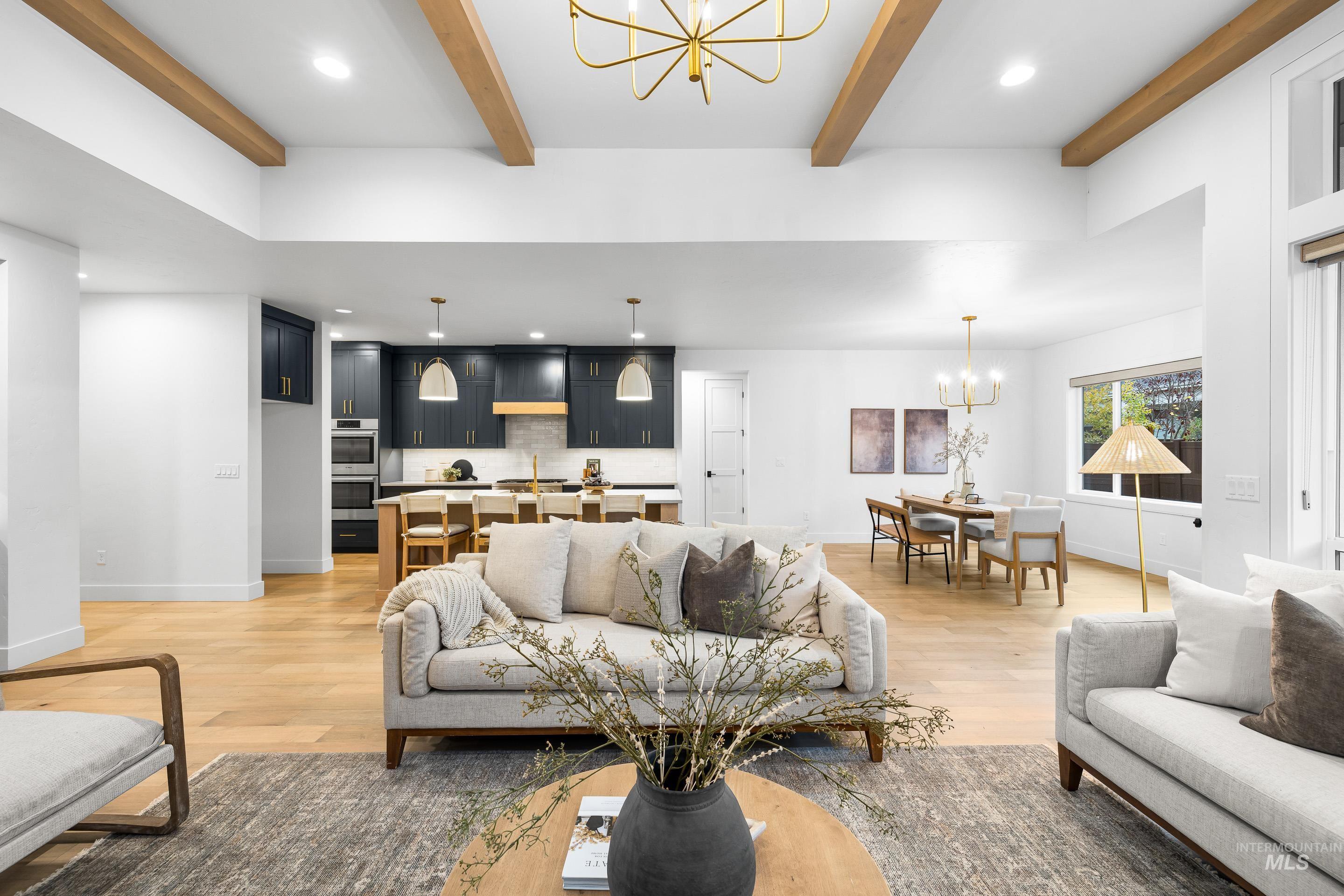 Living area featuring a chandelier, recessed lighting, light wood-style flooring, and beam ceiling
