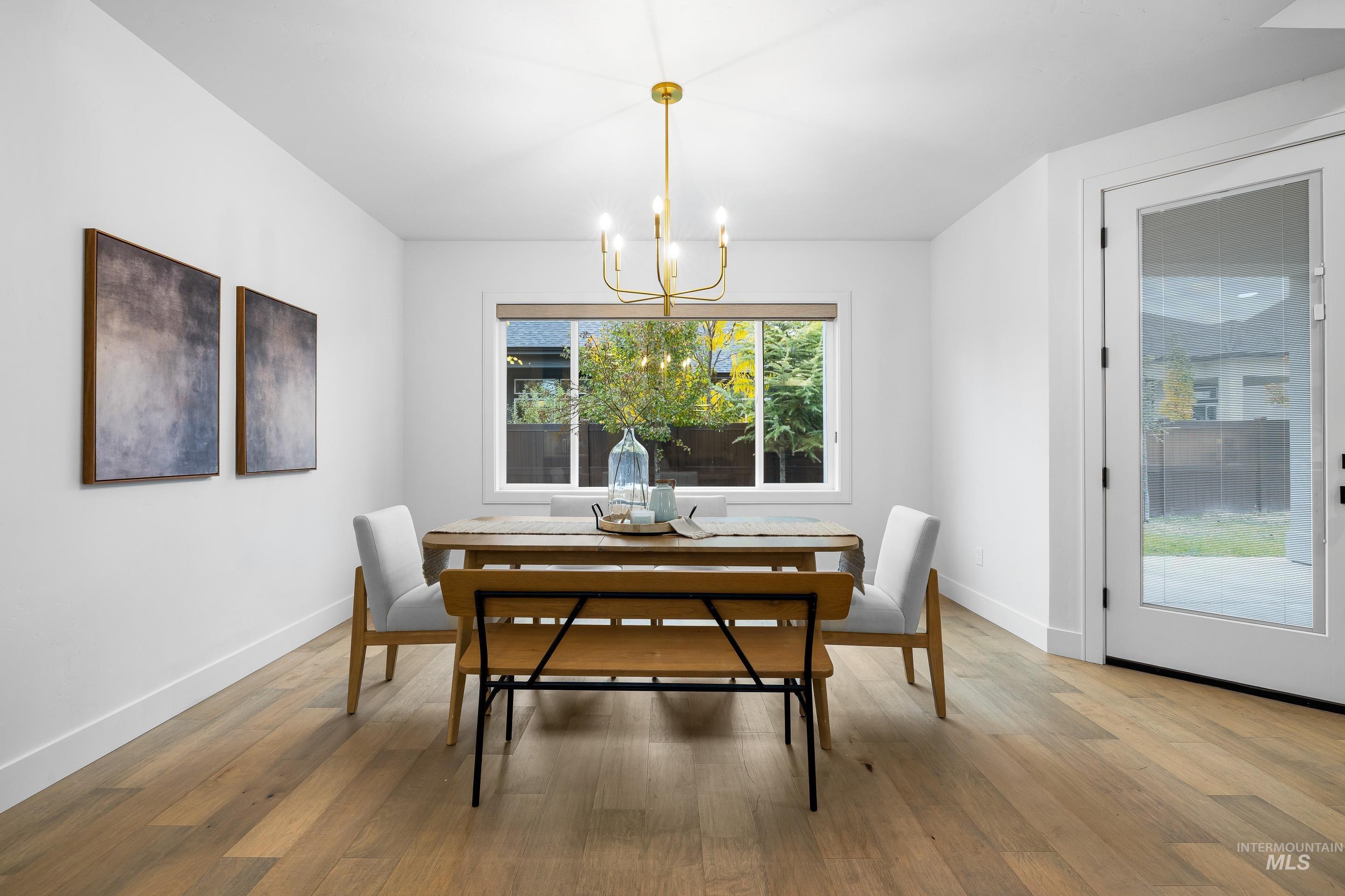 Dining space featuring light wood-style flooring and a chandelier