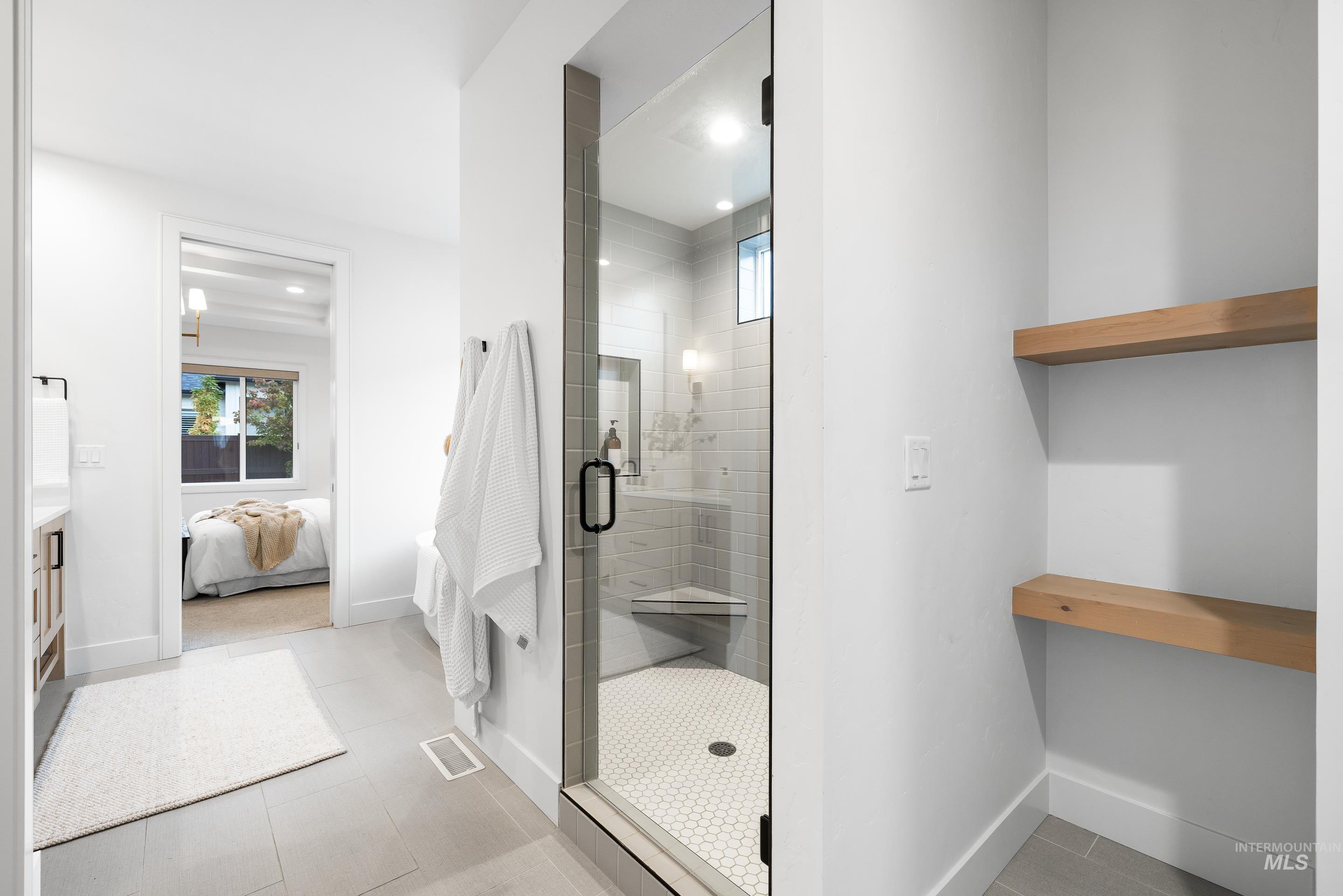 Bathroom featuring connected bathroom, a stall shower, recessed lighting, and light tile patterned flooring