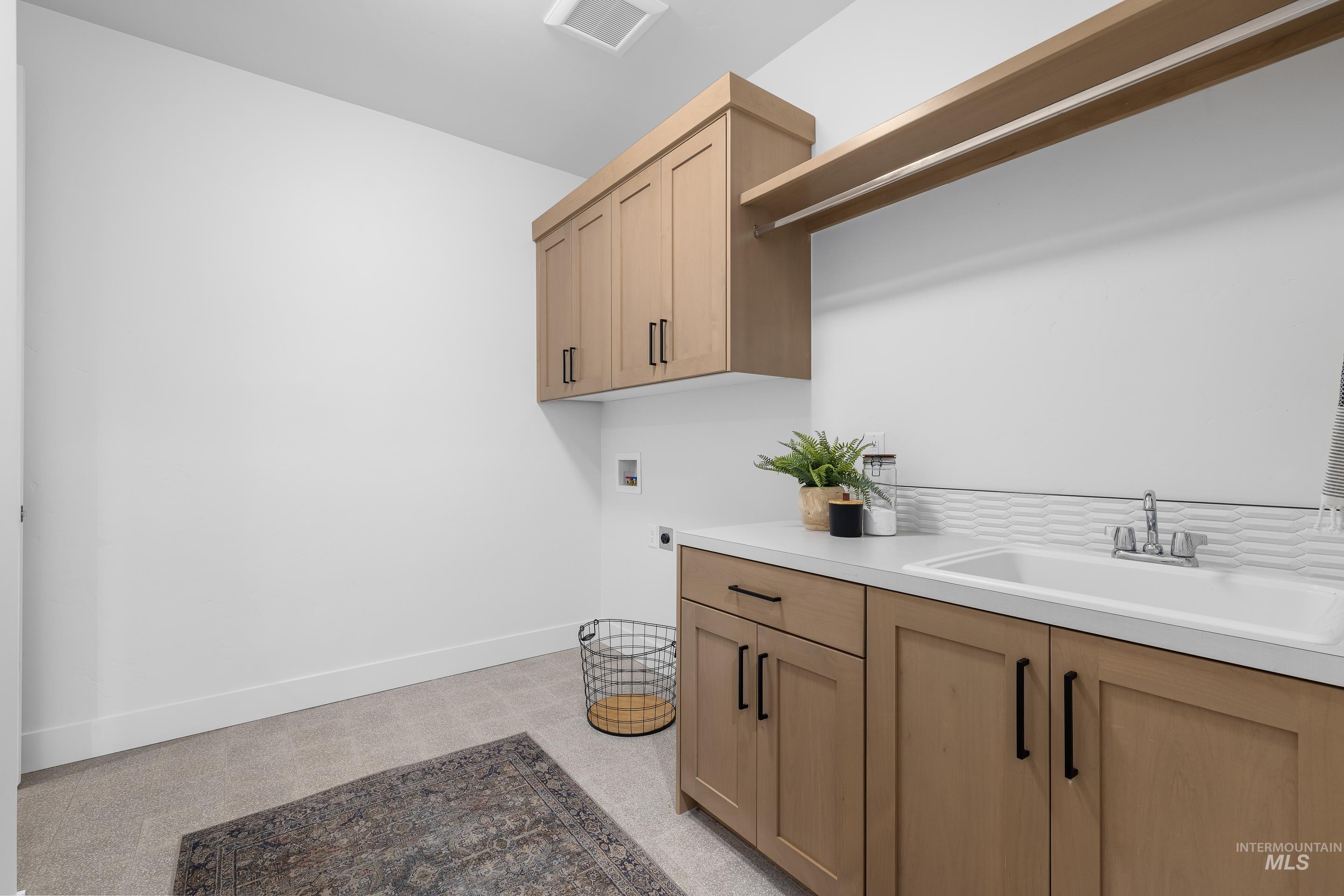 Laundry room with washer hookup and cabinet space
