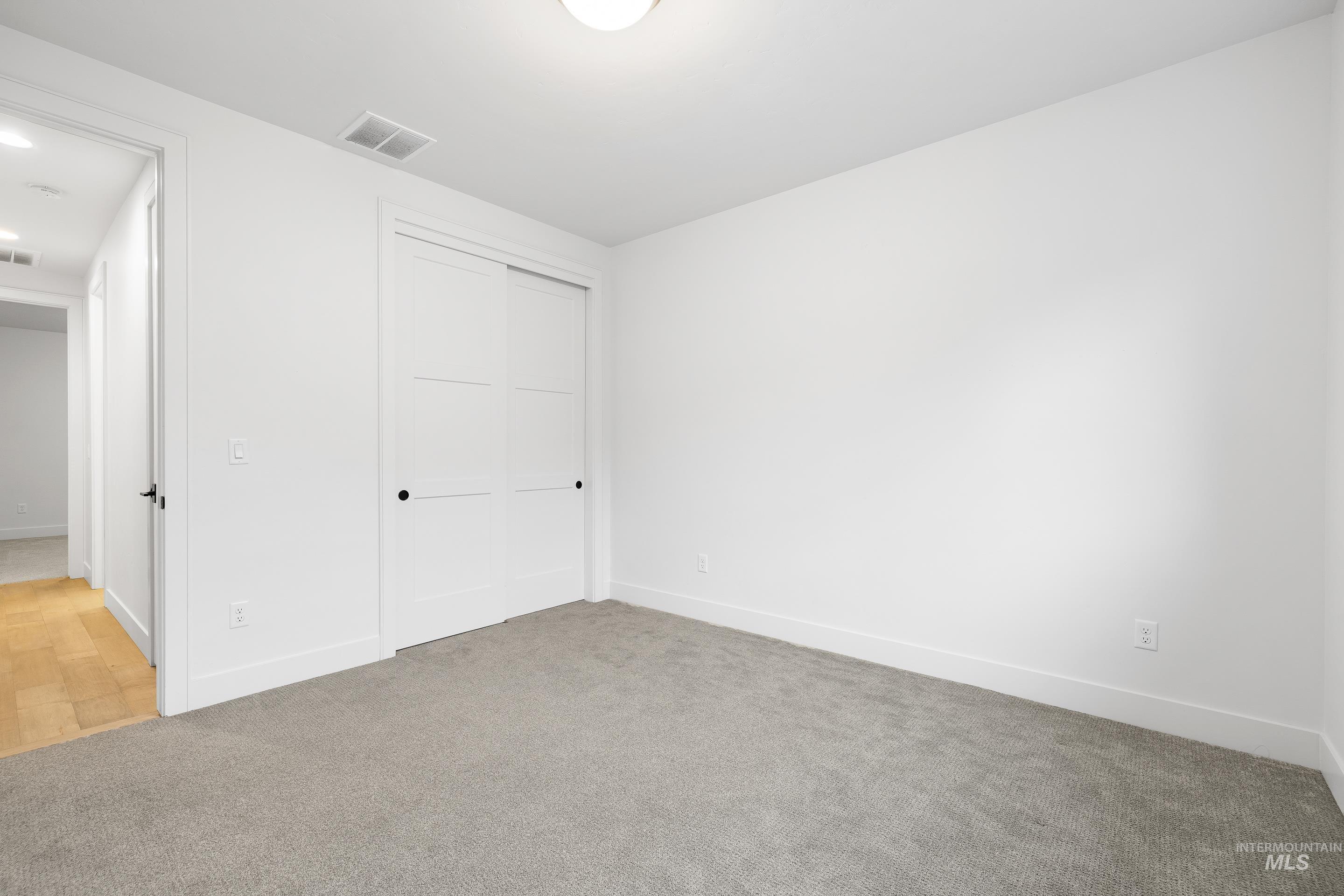 Unfurnished bedroom with carpet flooring and a closet