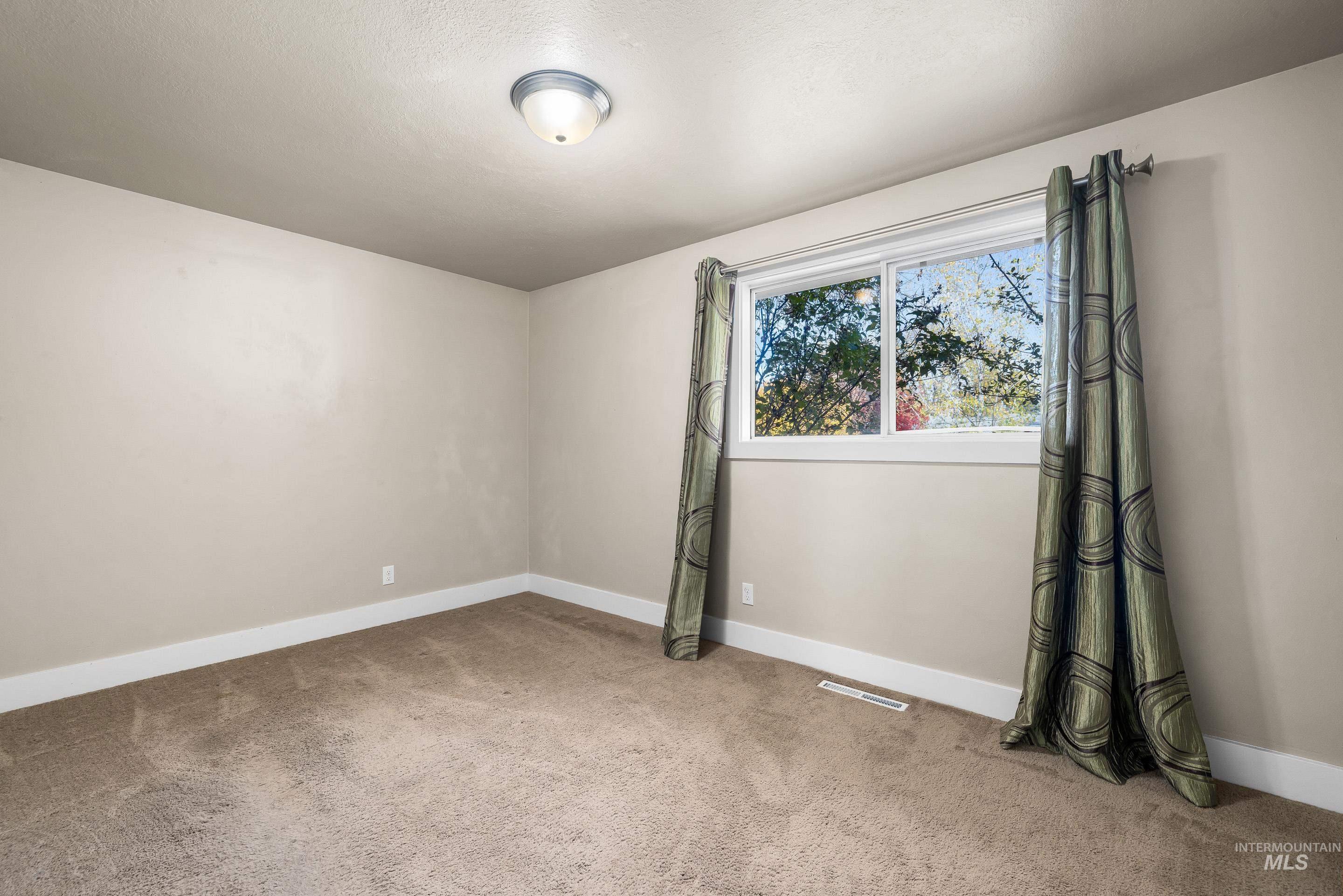 Carpeted empty room with baseboards