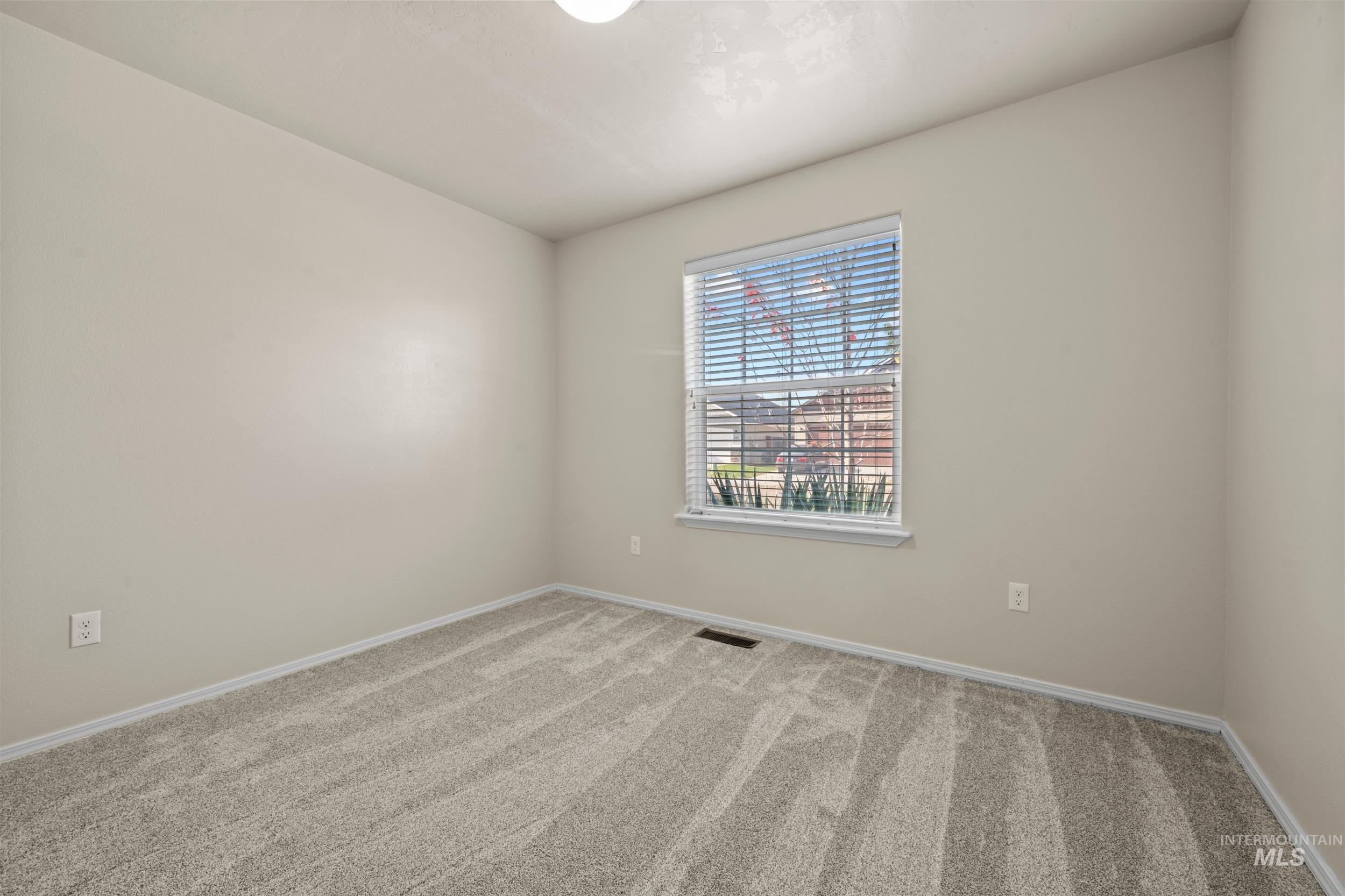 Carpeted spare room with baseboards